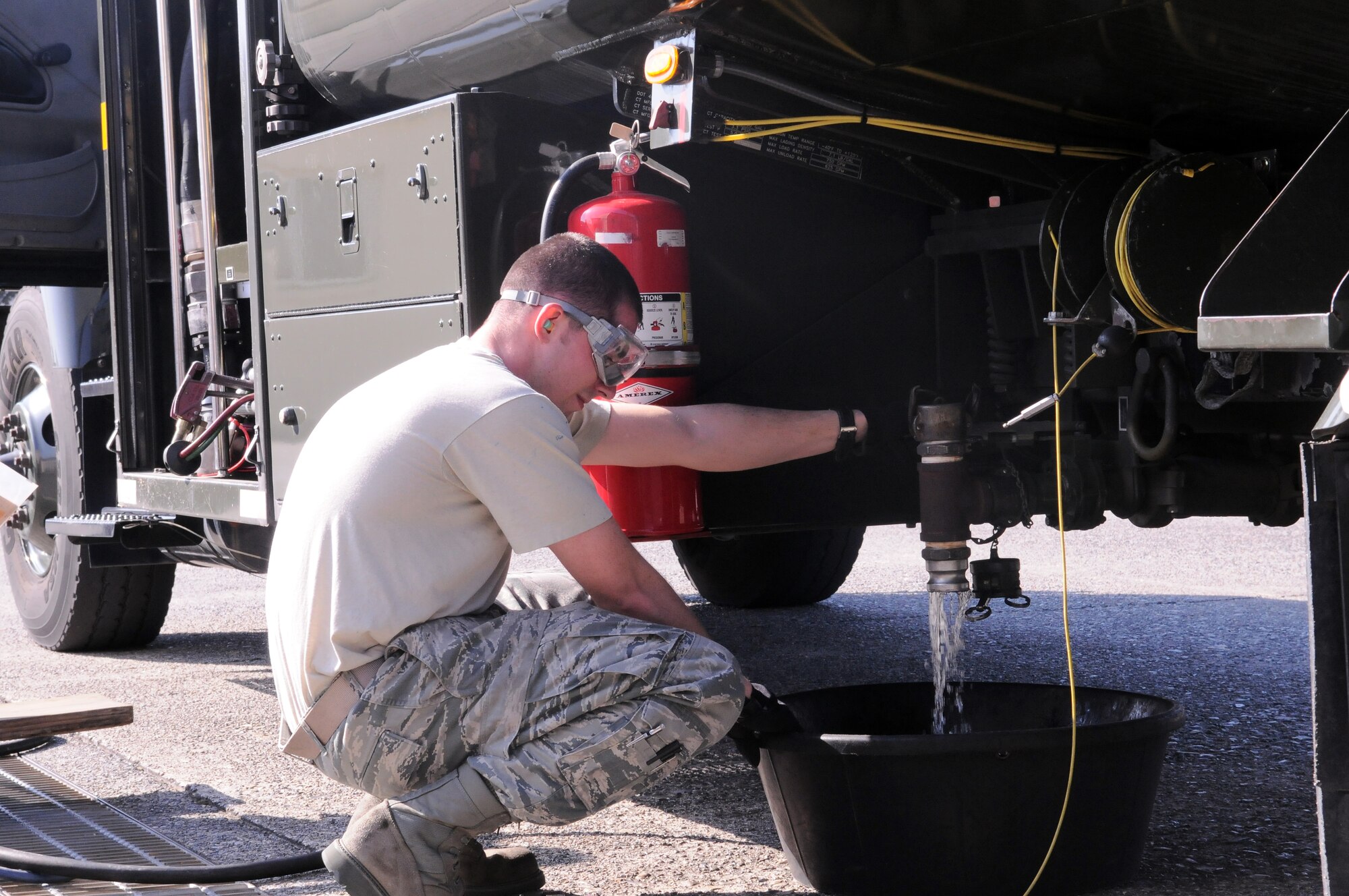 YOKOTA AIR BASE, Japan -- Airman Basic Justin Rose, 374th Logistics Readiness Squadron refueling maintenance technician, empties an R-11 fuel truck to prepare it for flight here, March 13. The fuel trucks were checked and prepared for transit to support forward aircraft providing relief to Japanese citizens affected by the earthquake and tsunami on the east coast of Japan, on March 11. (U.S. Air Force photo/Airman 1st Class Krystal M. Garrett)