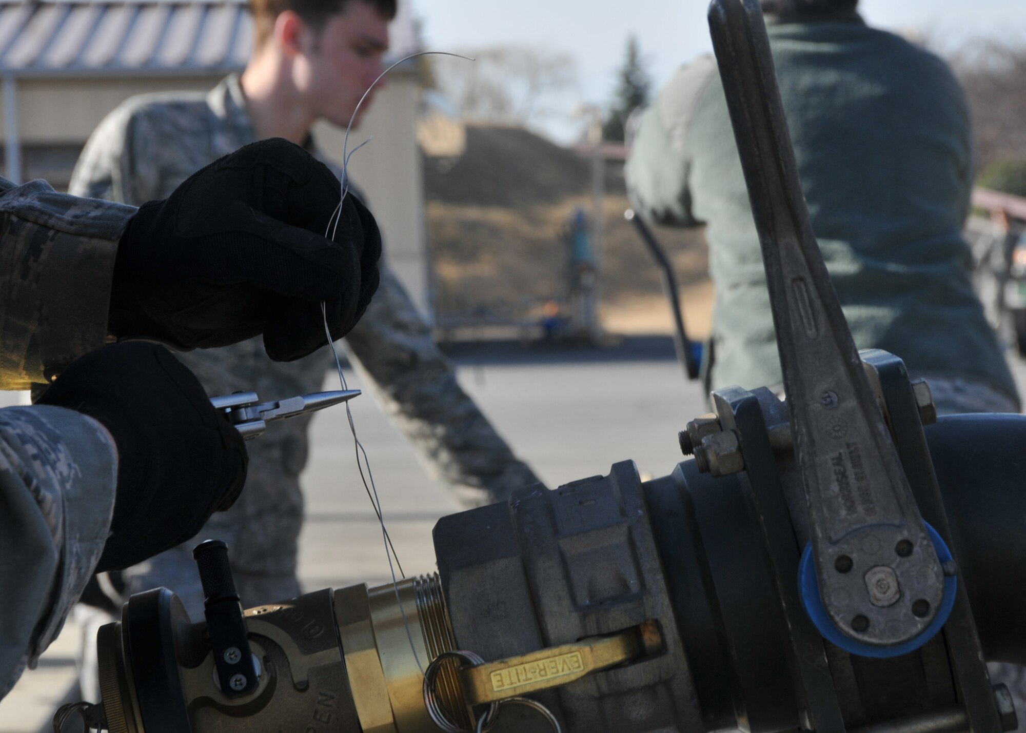 YOKOTA AIR BASE, Japan -- Airman 1st Class Morehead, 374th Logistics Readiness Squadron force support equipment operator, seals a fuel bladder valve here, on March 14. The fuel bladders were checked and prepared for transit to support forward aircraft providing relief to Japanese citizens affected by the earthquake and tsunami on the east coast of Japan, on March 11.  (U.S. Air Force photo/Airman 1st Class Andrea Salazar)