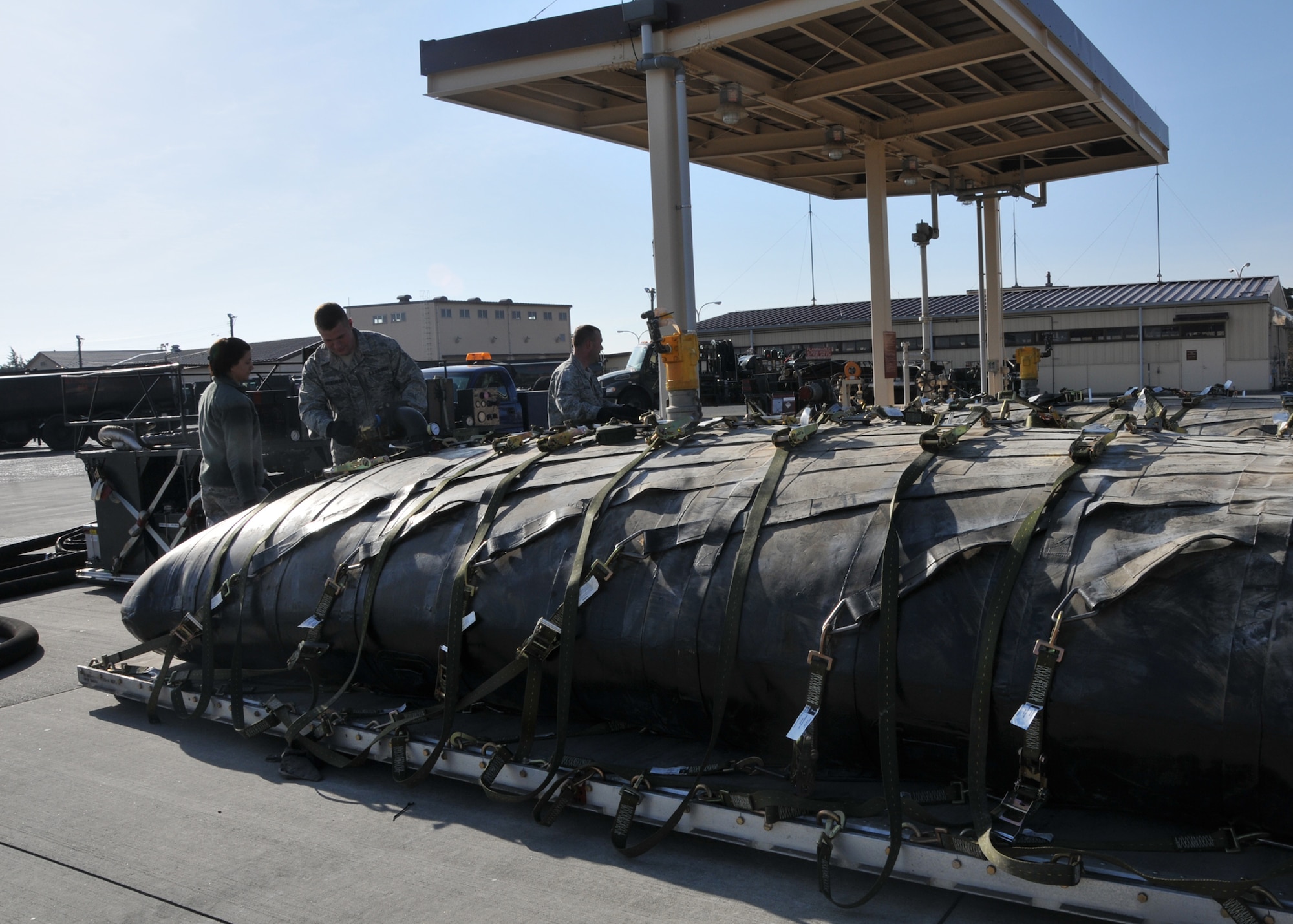 YOKOTA AIR BASE, Japan -- Airmen from the 374th Logistics Readiness Squadron petroleum, oils and lubricants flight check fuel bladders for leaks or other defects here, on March 14. The fuel bladders were checked and prepared for transit to support forward aircraft providing relief to Japanese citizens affected by the earthquake and tsunami on the east coast of Japan, on March 11. (U.S. Air Force photo/Airman 1st Class Andrea Salazar)