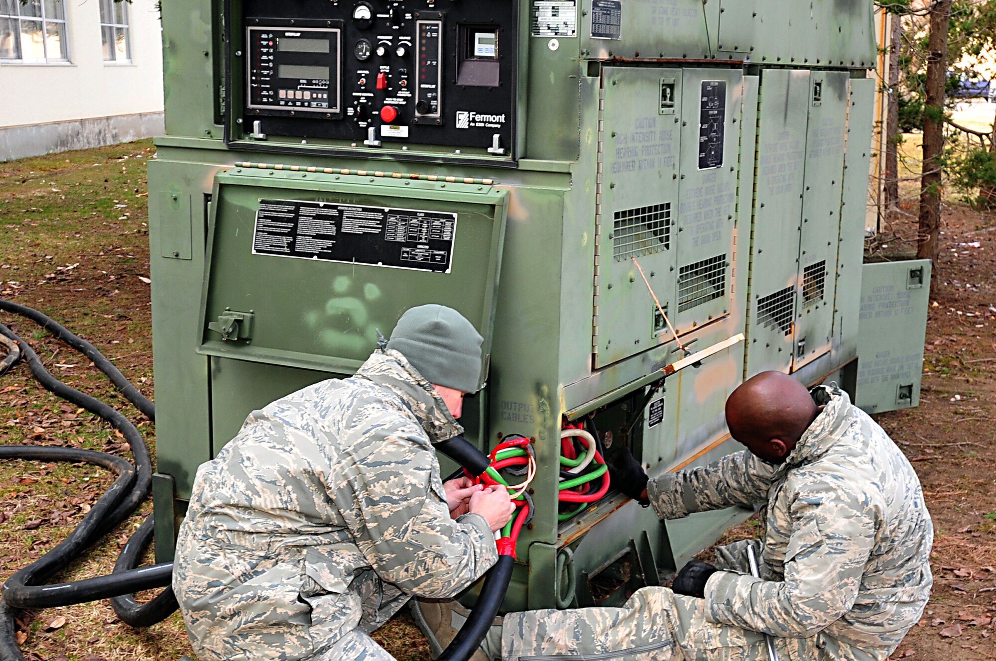 MISAWA AIR BASE, Japan -- U.S. Air Force Airman First Class Aaron Cope, right, and Tech. Sgt. Danny Dottin, connect power cables to a generator located at the Misawa Inn Mar. 14. Misawa Air Base lost power after feeling the effects of a 9.1 magnitude earthquake. Sergeant Dottin and Airman Cope are assigned to the 18th Civil Engineer Squadron, generator maintenance shop. (U.S. Air Force photo by Staff Sgt. Marie Brown\Released)
