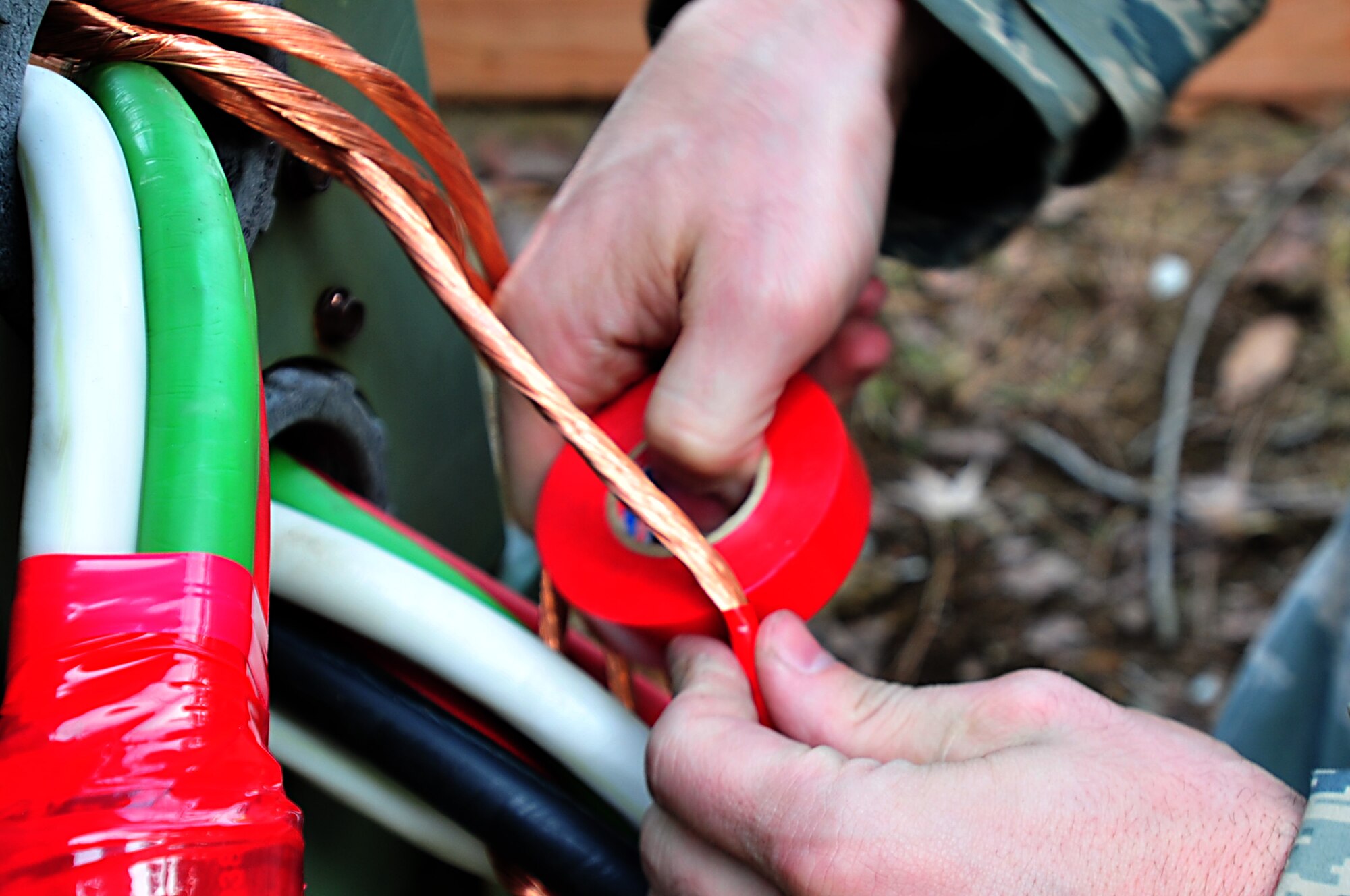 MISAWA AIR BASE, Japan -- U.S. Air Force Airman First Class Aaron Cope, 18th Civil Engineer Squadron, wraps tape around exposed wires on a generator Mar. 14. More than 50 Civil Engineer members and 11 generators arrived Mar. 12 from Kadena Air Force Base, Japan to aide in recovery operations. Airman Cope is assigned to the. (U.S. Air Force photo by Staff Sgt. Marie Brown\Released)
