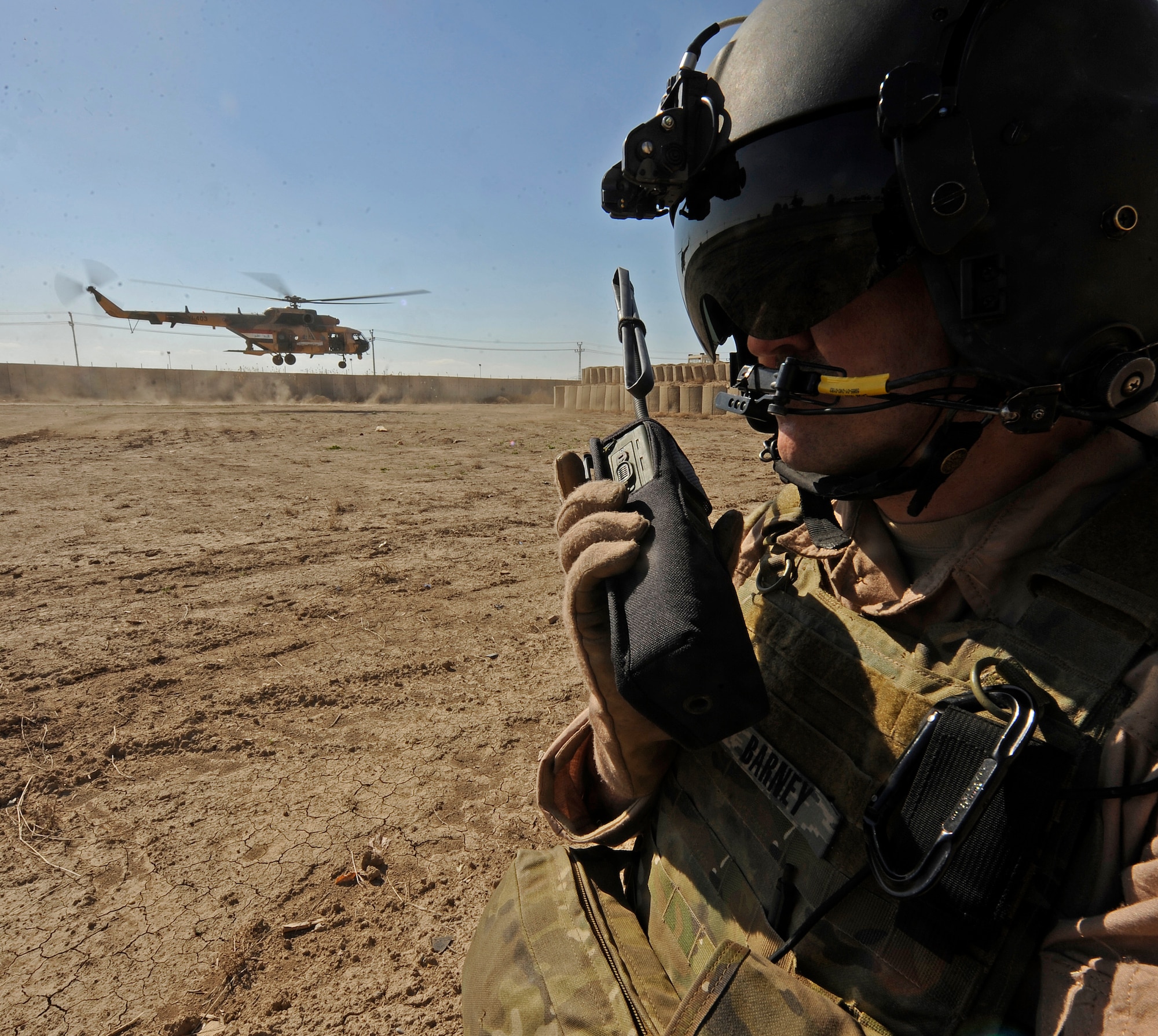 CAMP TAJI, Iraq -- Tech. Sgt. Everett Barney, a 721st Air Expeditionary Advisory Squadron aerial gunner, calls in for transport to an Iraqi Army Aviation Command Mi-171 multi-mission helicopter after conducting troop insertion training at a forward operating base near Baghdad International Airport March 2. Sergeant Barney is deployed from Moody Air Force Base, Ga. (U.S. Air Force/Tech. Sgt. Jason Lake)