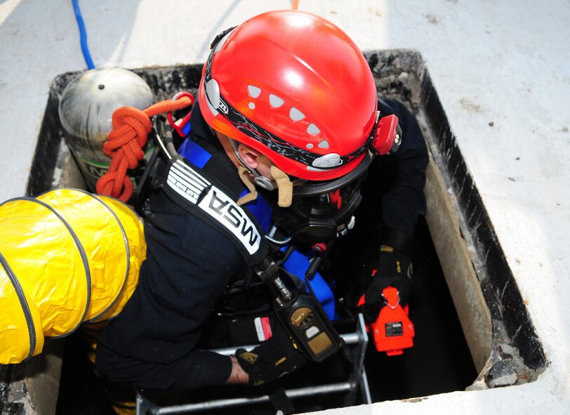 RAF MILDENHALL, England -- Crew Manager Dave Bootman, 100th Civil Engineer Squadron Fire Department, descends into the confined space trainer here March 8, 2011, during a training exercise in the newly-built facility. The trainer provides firefighters multiple ways of reaching a victim, allowing use of different equipment, depending on the scenario. Once inside, firefighters can face a variety of potential hazards, which make it more difficult for the rescuers to manouever a victim if a backboard, litter or basket has to be used. (U.S. Air Force photo/Karen Abeyasekere)