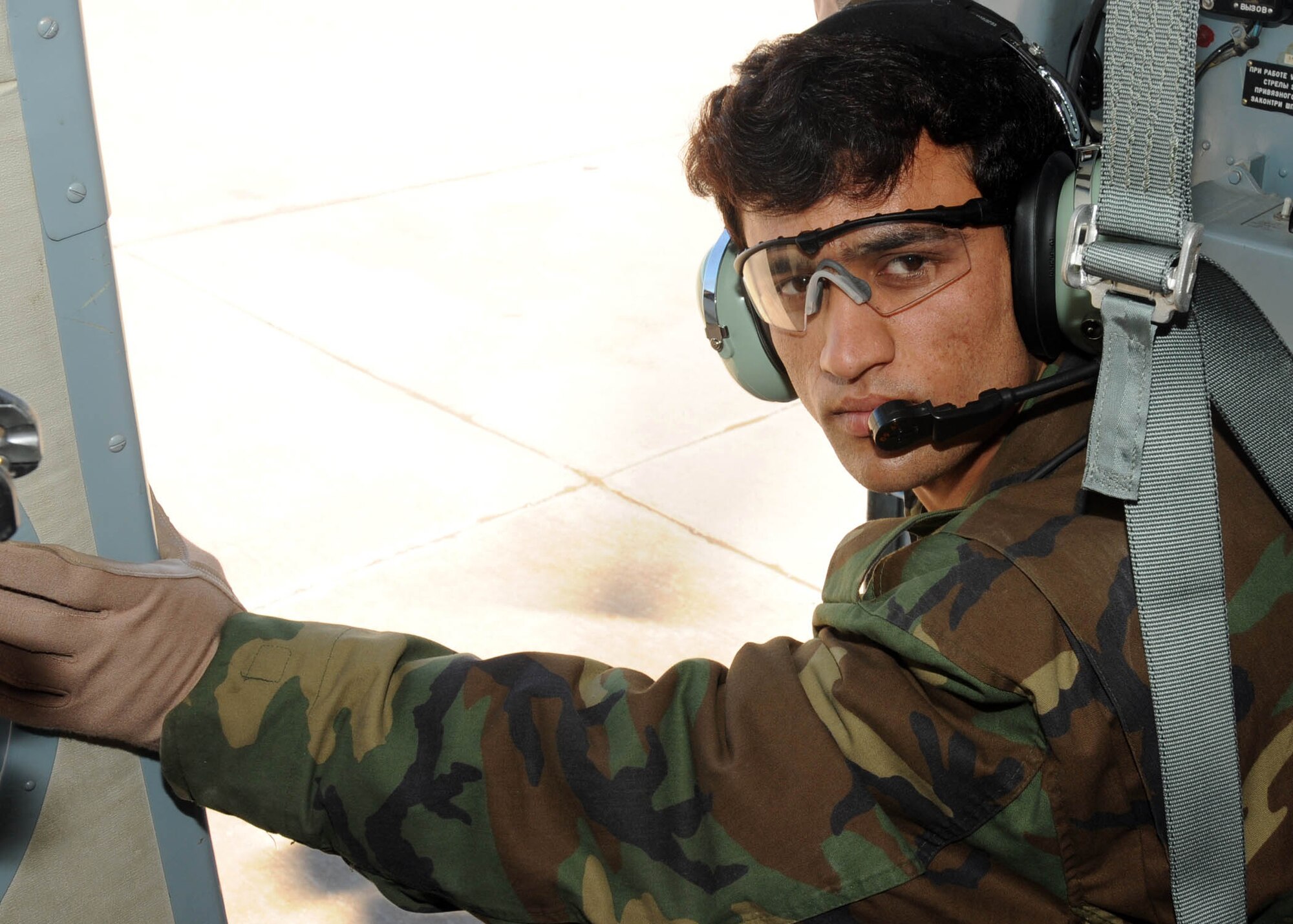 SHINDAND, Afghanistan - Afghan Air Force Staff Sgt. Mohammad Shafi, one of the Afghan flying crew chief students, sits on a Mi-17 getting ready for his first flight as a flying crew chief around Shindand, Afghanistan. (U.S. Navy photo by Mass Communications Specialist 3rd Class Jared E. Walker).