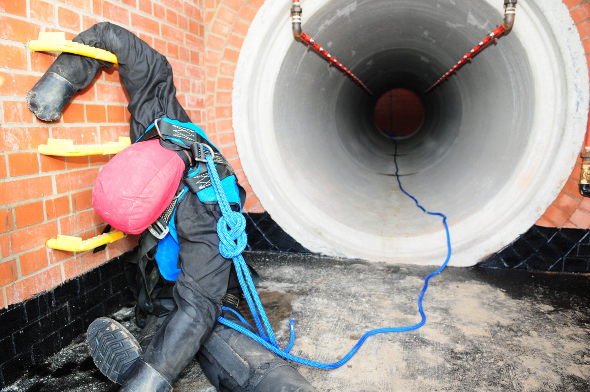 RAF MILDENHALL, England -- A mannequin, precariously caught up on steps, simulates a casualty who has fallen into a tunnel, before firefighters enter the area on a training exercise March 8, 2011. The confined space trainer is a new facility that allows the 100th Civil Engineer Squadron Fire Department, along with other flights from 100th CES, 100th Communications Squadron and the 352nd Special Operations Group, to perform a variety of training purposes. The red pipes are water lines and the trainer will be hooked up to a water supply and partly filled on occasion, to make training more difficult and to simulate emergency situations. (U.S. Air Force photo/Karen Abeyasekere)