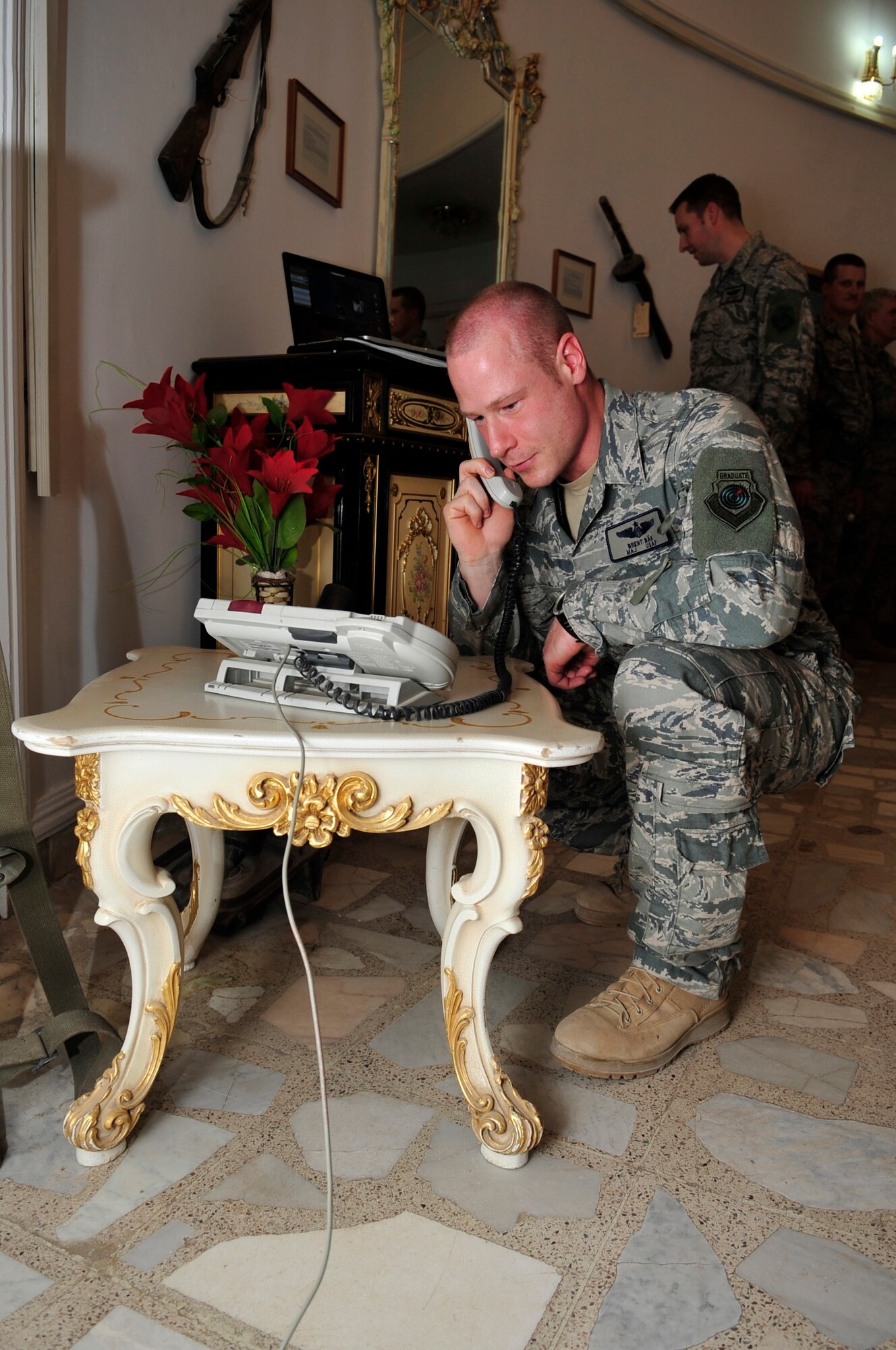 Maj. Brent Bak, 9th Air and Space Expeditionary Task Force-Iraq, talks with his wife following his promotion ceremony to major Camp Victory, Baghdad, Feb. 28, 2011. Presiding over the ceremony was Brig. Gen. Russ Handy, 9th AETF-I commander. (Air Force photo by Senior Master Sgt. Larry Schneck/Released)