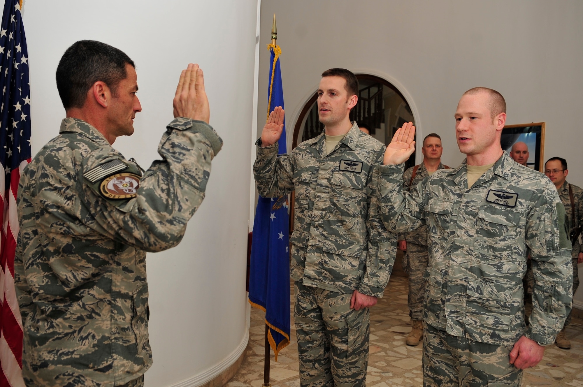 Brig. Gen. Russ Handy, 9th Air and Space Expeditionary Task Force-Iraq commander, administers the oath of office to Maj. Brent Bak and Maj. Ryan McLain, 9th AETF-I, during their promotion ceremony to major Camp Victory, Baghdad, Feb. 28, 2011. (Air Force photo by Senior Master Sgt. Larry Schneck/Released)