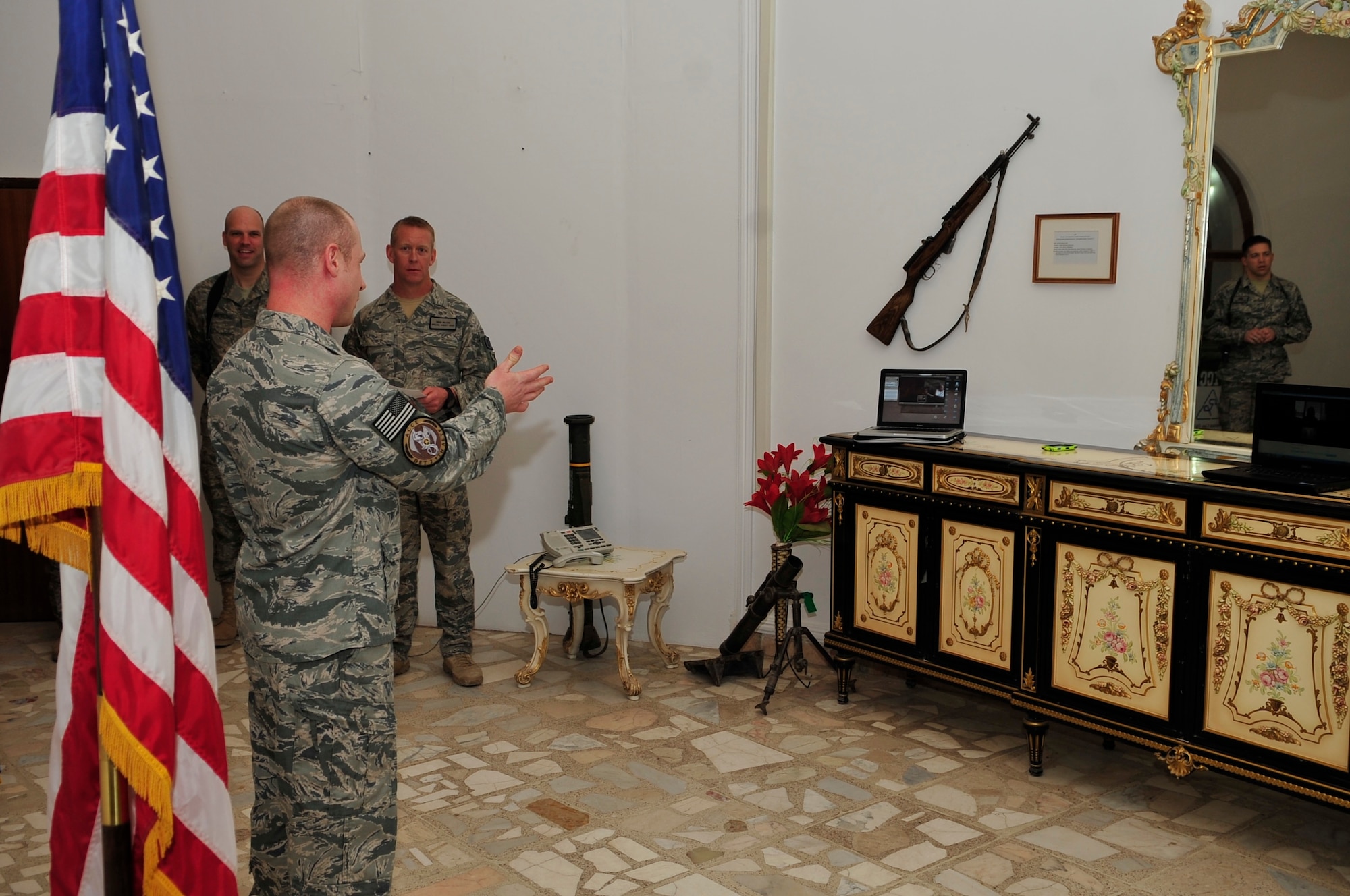 Capt. Brent Bak, 9th Air and Space Expeditionary Task Force-Iraq, talks with Gen. (ret.) T. Michael Moseley, former Air Force Chief of Staff, and his family through speaker phone and video chat during Captain Bak’s promotion ceremony to major Camp Victory, Baghdad, Feb. 28, 2011. Presiding over the ceremony was Brig. Gen. Russ Handy, 9th AETF-I commander. (Air Force photo by Senior Master Sgt. Larry Schneck/Released)
