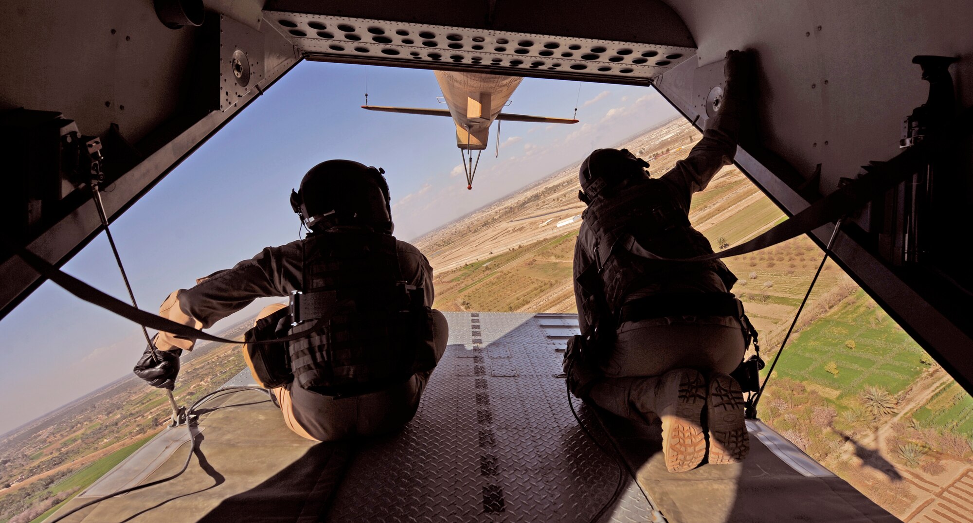 CAMP TAJI, Iraq -- U.S. Air Force Tech. Sgt. Everett Barney, right, 721st Air Expeditionary Advisory Squadron aerial gunner, and his Iraqi Army Aviation Command partner scan the horizon for hostile fire on an Mi-171 multi-mission helicopter training flight March 2. Iraq Training and Advisory Mission - Air advisors conducted troop insertion training with their Iraqi partners at a forward operating base near Baghdad International Airport. (U.S. Air Force/Tech. Sgt. Jason Lake)