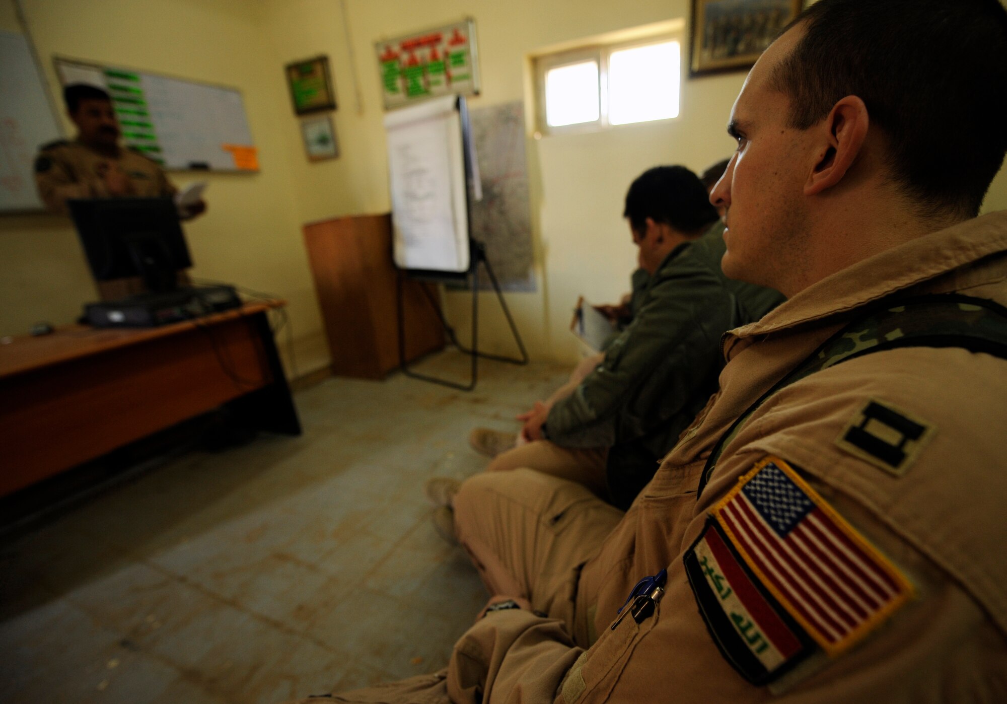 CAMP TAJI, Iraq -- U.S. Air Force Capt. Christopher Hart, right, an Mi-171 advisor pilot for Iraqi Army Aviation Command, listens as an Iraqi officer presents a pre-flight mission briefing to American and Iraqi aircrews March 2. Captain Hart is a UH-1N pilot deployed from Kirtland Air Force Base's 512th Rescue Squadron in New Mexico. (U.S. Air Force/Tech. Sgt. Jason Lake)