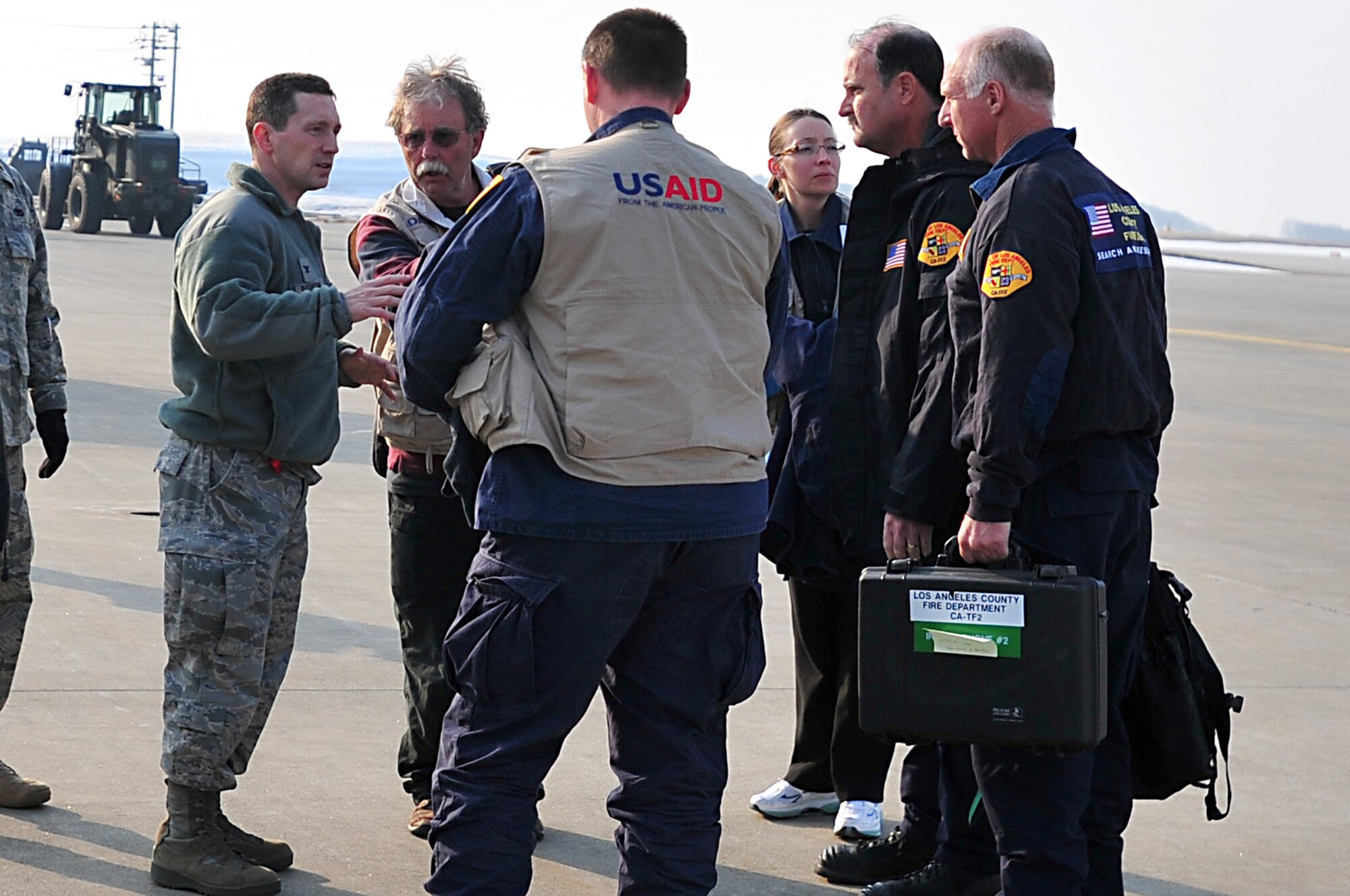 MISAWA AIR BASE, Japan -- Col. Michael Rothstein, 35th Fighter Wing commander, talks with United States Agency for International Development search and rescue team members on the flightline Mar. 13. Teams from Los Angeles County Fire Department, Calif. and Fairfax County, Va. Urban Search and Rescue arrived in support of Operation Tomodachi to assist with civil relief and recovery operations. (U.S. Air Force photo by Staff Sgt. Marie Brown\Released)
