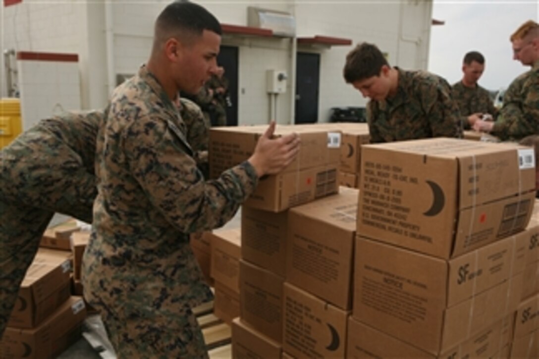 U.S. Marines assigned to Combat Logistics Regiment 37, 3rd Marine Logistics Group, III Marine Expeditionary Force load food onto a cargo platform to deliver to Japanese residents after an earthquake and a tsunami struck the island nation at Marine Corps Air Station Futenma on Okinawa, Japan, on March 11, 2011.  