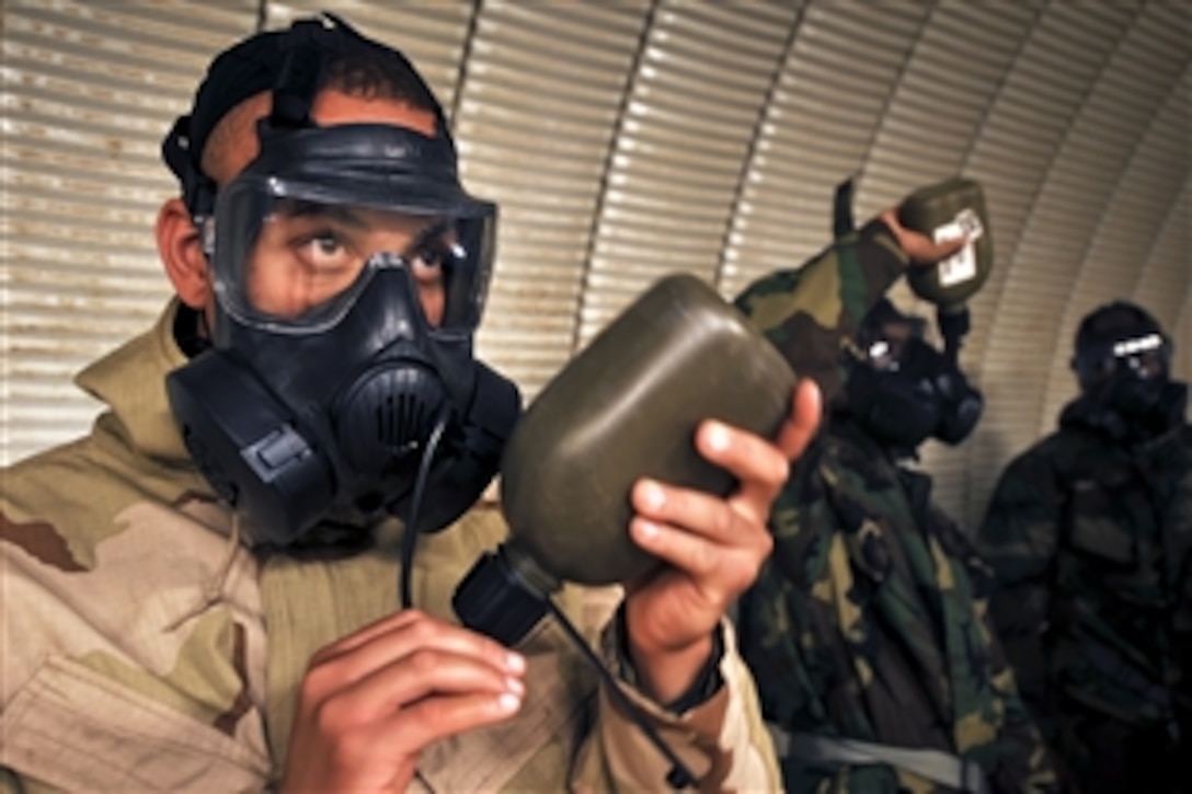 U.S. Marine Corps Sgt. Carl Miller drinks from a canteen attached to his XM50 joint-service general-purpose mask in a tear-gas filled chamber on Camp Pendleton, Calif., March 10, 2011. Miller, assigned to the 11th Marine Expeditionary Unit, and about 100 unit members, drilled with the masks as part of chemical-biological-radiological-nuclear defense training.