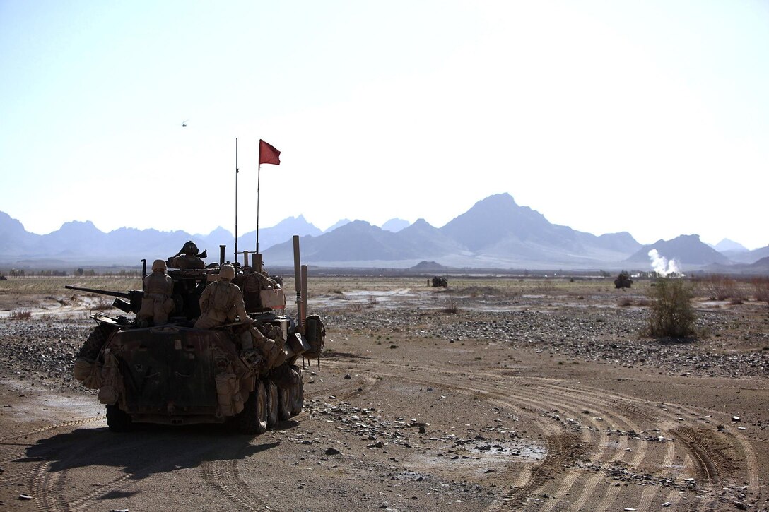 A light armored vehicle crew with C Company, 3rd Light Armored Reconnaissance Battalion, watches a Marine AH-1W Super Cobra helicopter veer off after destroying an insurgent structure in the Bahram Chah bazaar with a Hellfire missile during Operation Rawhide II, Helmand province, Afghanistan, March 14. During the four-day raid on the key insurgent trafficking point on the Pakistan border, 3rd LAR Battalion Marines used virtually every supporting arms asset available to the Marine Corps to destroy insurgent structures and suppress and kill enemy fighters.