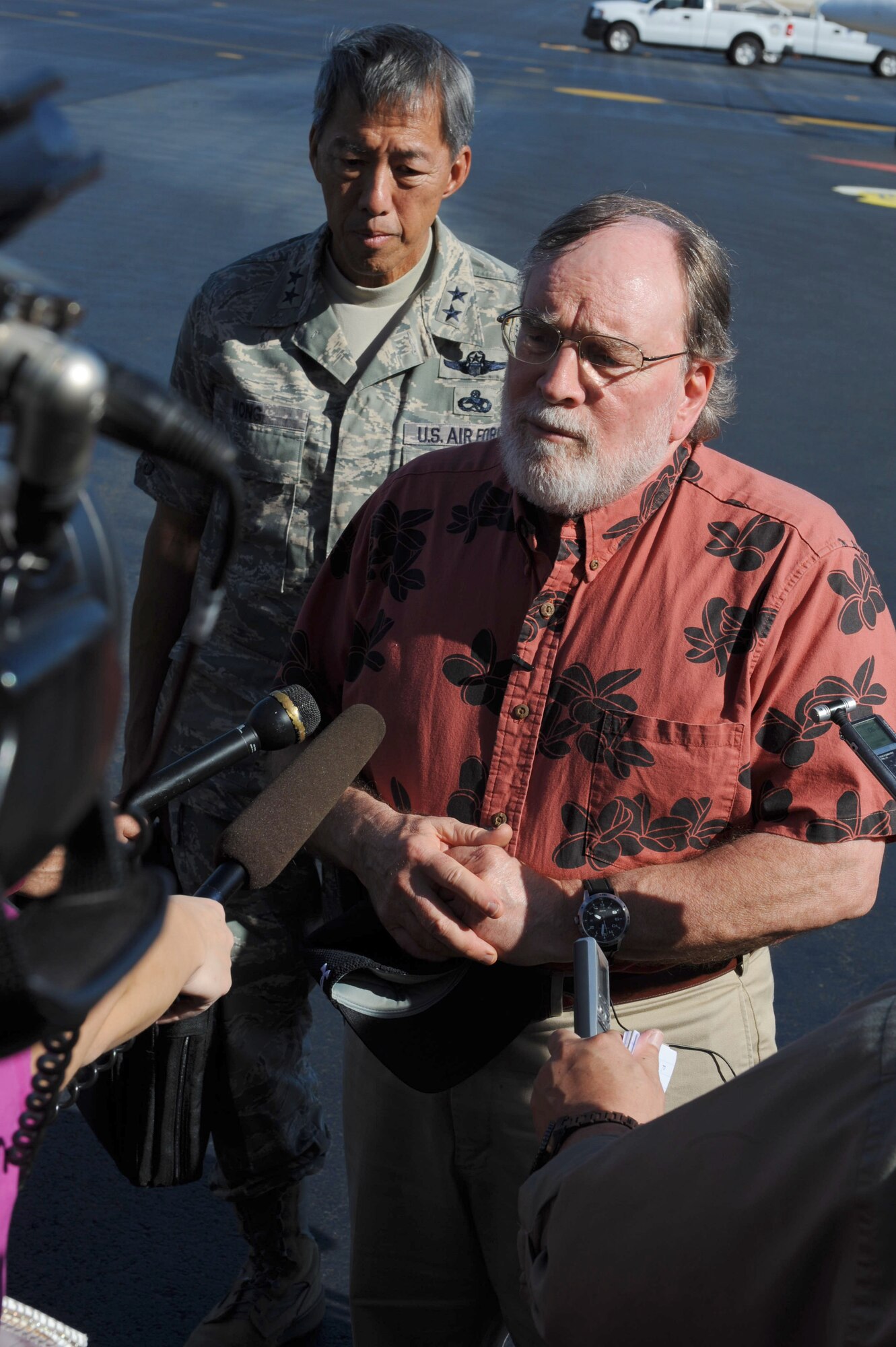 U.S. Air Force Maj. Gen. Darryll D.M. Wong; the Director of Land and Natural Resources, and Hawaii State Governor Neil Abercrombie speaks to local media on the 15th Wing flight line at Joint Base Pearl Harbor-Hickam, Hawaii, March 15. Governor Abercrombie flew over the Hawaiian Islands with, Maj. Gen. Darryll D.M. Wong, Mr. William Aila; and the Hawaii National Guard's Joint Chief of Staff, Army Col. Joe Logan, to conduct damage assessment after a tsunami hit the islands March 11. They flew in a Hawaii Army National Guard aircraft and landed on the U.S. Air Force flight line. (U.S. Air Force photo/Airman 1st Class Lauren Main)
