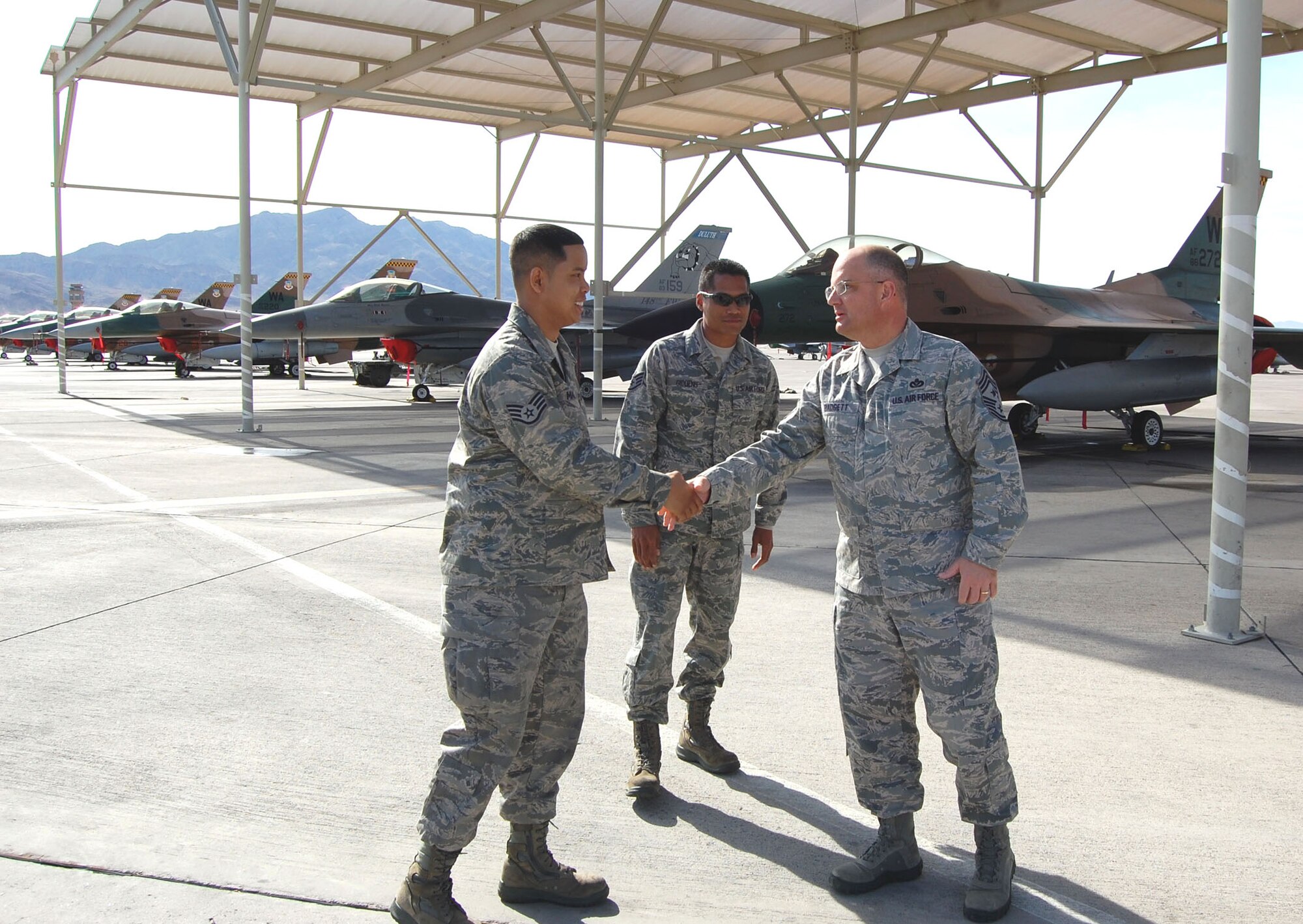 NELLIS AIR FORCE BASE, Nev. - (Left to right) Staff Sgt. Allan Maerina and Staff Sgt. Michael Giddens provide a tour of the F-16 Falcon to Chief Master Sgt. Dwight Badgett, Air Force Reserve Command Chief on March 6. Sergeant Maerina and Sergeant Giddens are integrated into the 57th Maintenance Group here, working on Aggressor aircraft used in Red Flag exercises. (U.S. Air Force photo/Capt. Jessica Martin)