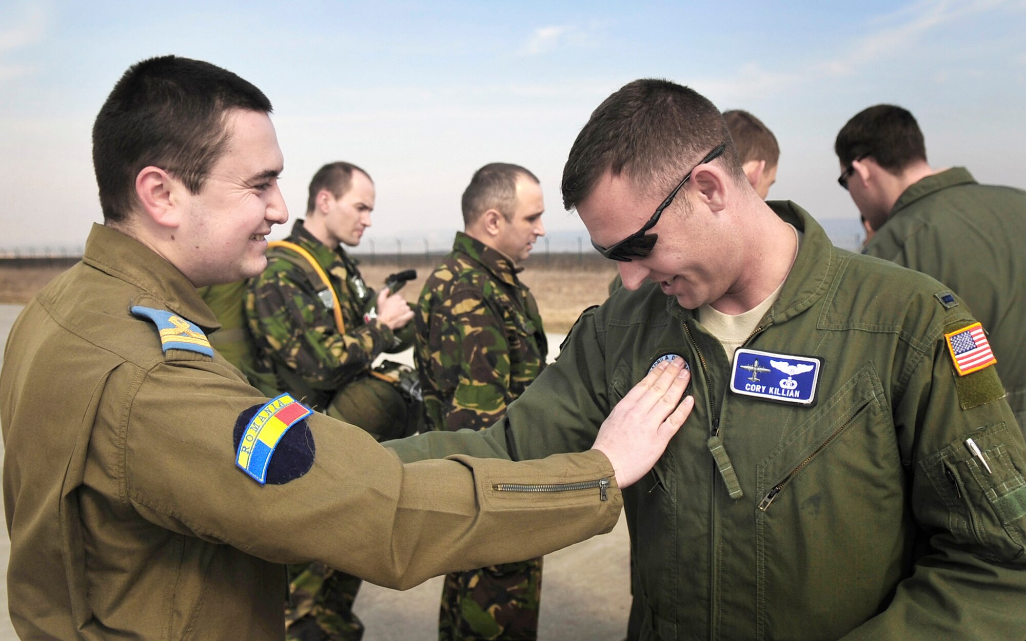 Lt. Daniel Motoroui, a Romanian air force pilot, exchanges a patch with 1st Lt. Cory Killian March 14, 2011, at Campia Turzii, Romania. Lieutenant Killian introduced this tradition to Lieutenant Motoroui after the first leg of their first flying mission of Carpathian Spring 2011, an exercise where members of the U.S. military join their Romanian counterparts to learn from one another and strengthen alliances. Lieutenant Killian is a pilot assigned to the 37th Airlift Squadron. (U.S. Air Force photo/Tech. Sgt. Jocelyn L. Rich)