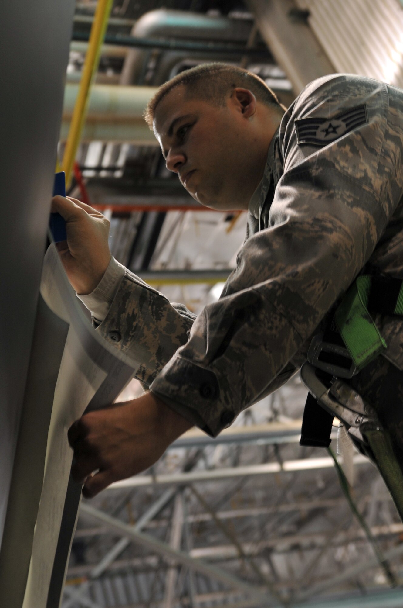 MINOT AIR FORCE BASE, N.D. -- Staff Sgt. Adam Lewis, 5th Maintenance Squadron aircraft structural maintenance craftsman, puts the finishing touches on a decal on the side of a B-52H Stratofortress, here March 11. This was the first jet at Minot to receive the decals instead of being painted.  (U.S. Air Force photo/Airman 1st Class Jessica McConnell)
