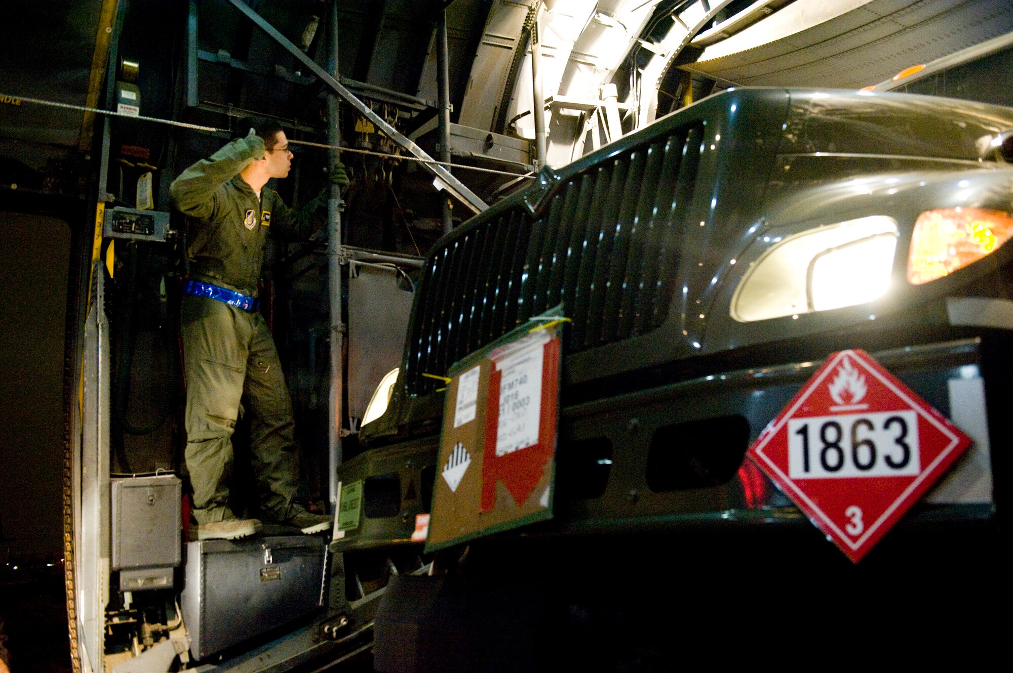 Airman 1st Class Giovanny Miranda, 36th Airlift Squadron, watches the sides for clearance as a fuels truck is loaded onto a C-130H Hercules here March 15. The fuels truck was taken to Yamagota Airport to support Japan'e earthquake and tsunami relief efforts. (U.S. Air Force photo/Staff Sgt. Jonathan Steffen)