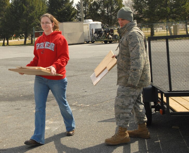 Staff Sgt. Matt Giacona and his wife, Jennifer, carry scrap wood to a roll-off bin for recycling March 14, 2011, at the Dover Air Force Base, Del., Recycling Center. The two were recycling pieces of scrap wood from a home project. Sergeant Giacona is an electrical systems craftsman with the 436th Civil Engineer Squadron. (U.S. Air Force photo by Airman 1st Class Matthew Hubby)