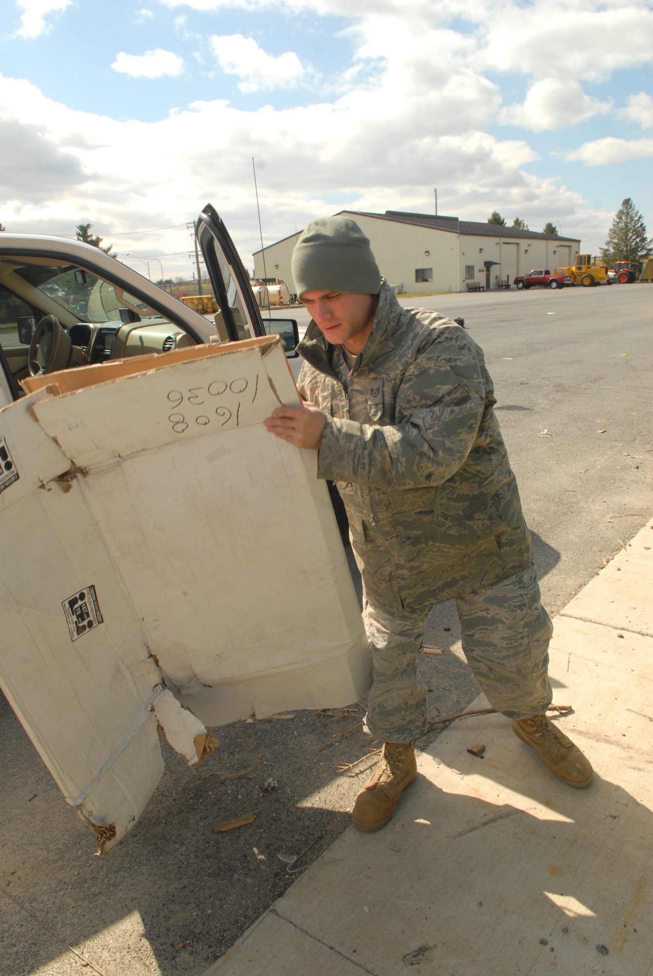 Staff Sgt. Matt Giacona, 436th Civil Engineer Squadron, carries scrap cardboard to a roll-off bin for recycling March 14, 2011, at the Dover Air Force Base, Del., Recycling Center. (U.S. Air Force photo by Airman 1st Class Matthew Hubby)
