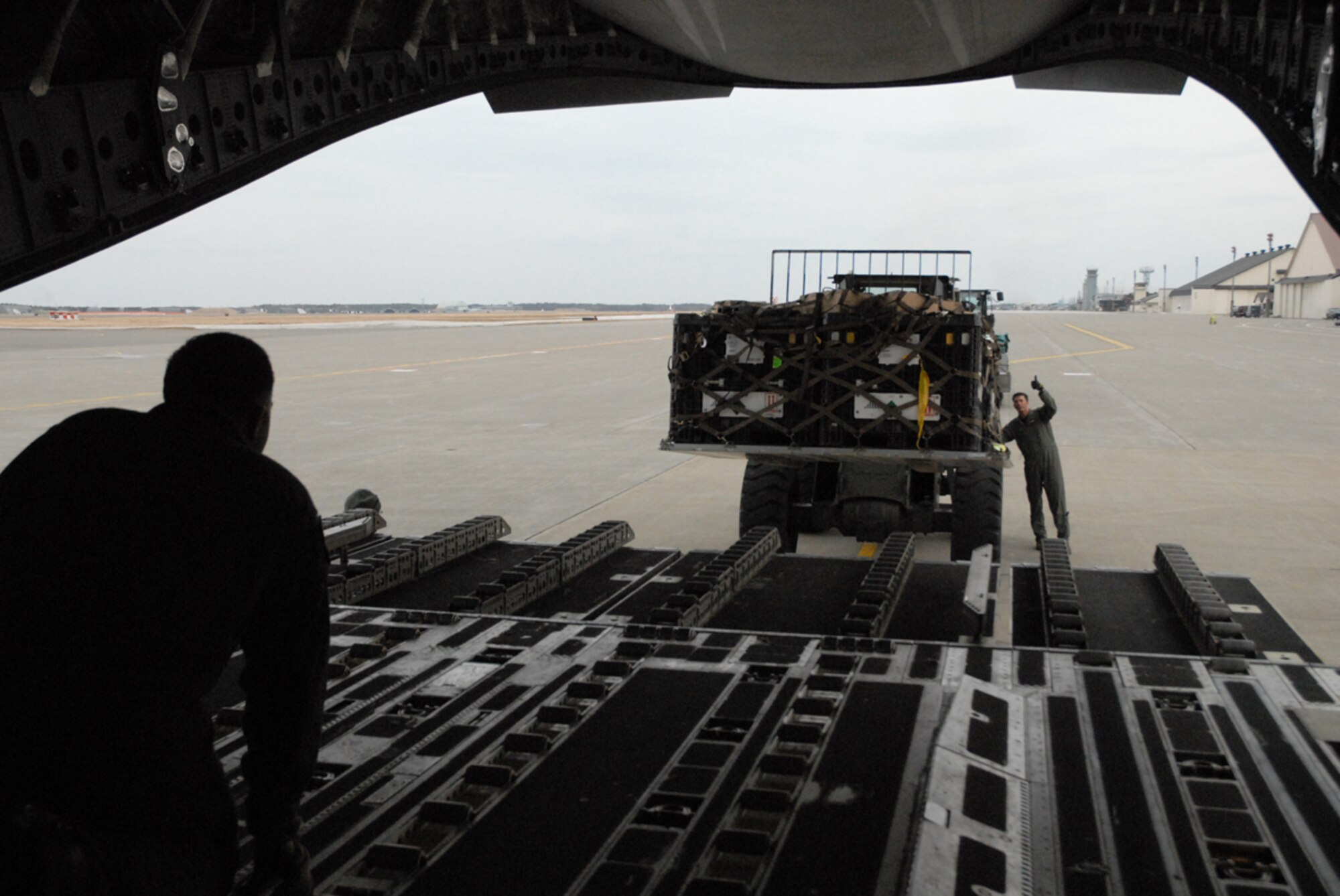 Joint Base Elmendorf-Richardson, Alaska -- Staff Sgt. Adam Koerner and Master Sgt. Stephen Mallory, both Air Force loadmasters stationed at the 517th Airlift Squadron, Joint Base Elmendorf-Richardson Alaska, marshal humanitarian relief pallets of USAID search and rescue gear into a C-17 Globemaster III destined for Yokota Air Base, Japan. (U.S. Air Force photo/Staff Sgt. Mark Leahy)