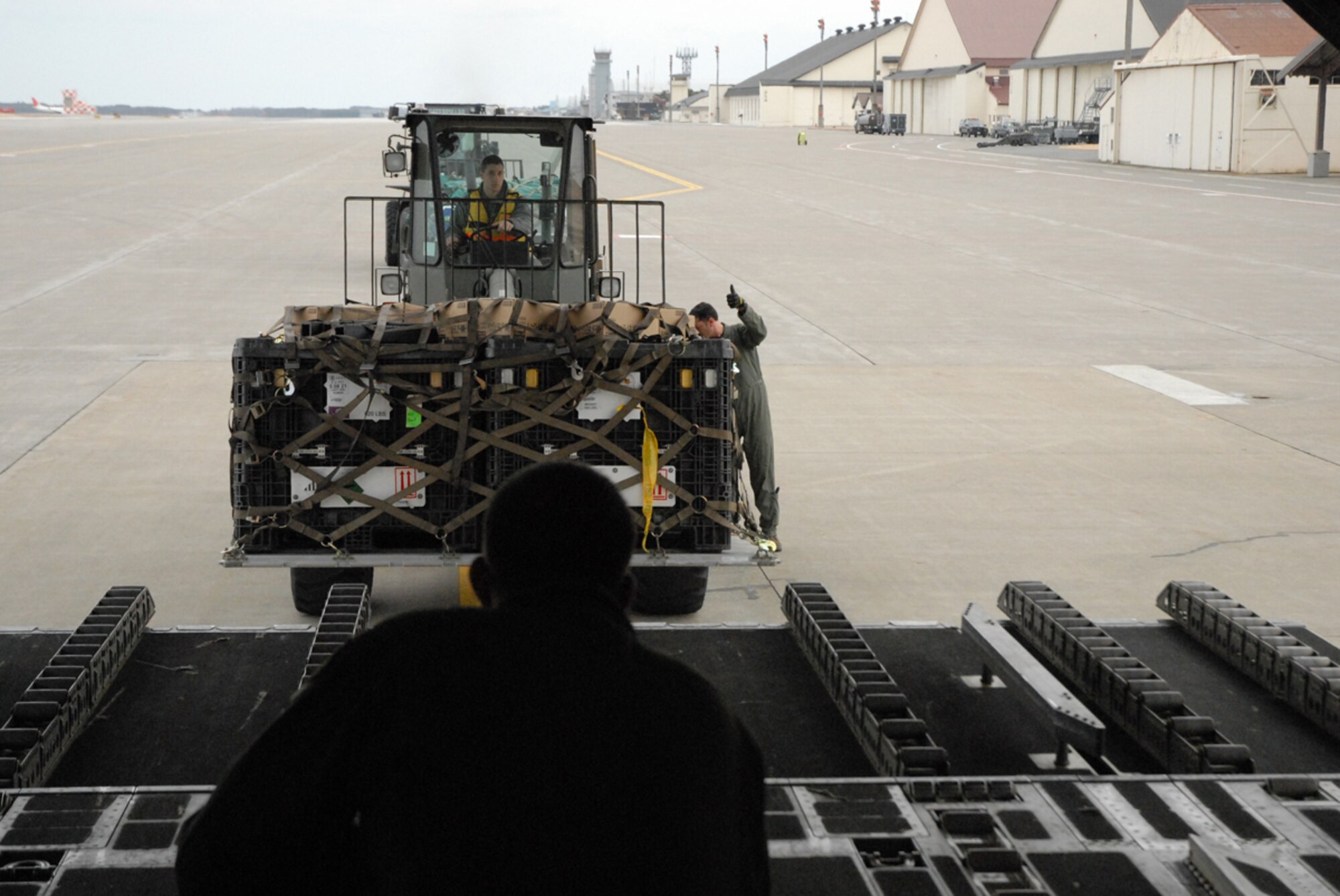 Joint Base Elmendorf-Richardson, Alaska -- Staff Sgt. Adam Koerner and Master Sgt. Stephen Mallory, both Air Force loadmasters stationed at the 517th Airlift Squadron, Joint Base Elmendorf-Richardson Alaska, marshal humanitarian relief pallets of USAID search and rescue gear into a C-17 Globemaster III destined for Yokota Air Base, Japan. (U.S. Air Force photo/Staff Sgt. Mark Leahy)