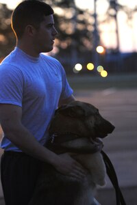 Senior Airman Joel Patterson and Elmo play before physical trainingMarch 14 on Joint Base Charleston Air Base.  Airman Patterson is a dog handler and Elmo is a military working dog and are assigned to the 628th Security Forces Squadron.  Dog handlers from the 628 SFS reguarly do physical training with thier dogs to give them much needed exercise and play time.  (U.S. Air Force photo/ Staff Sgt. Nicole Mickle)