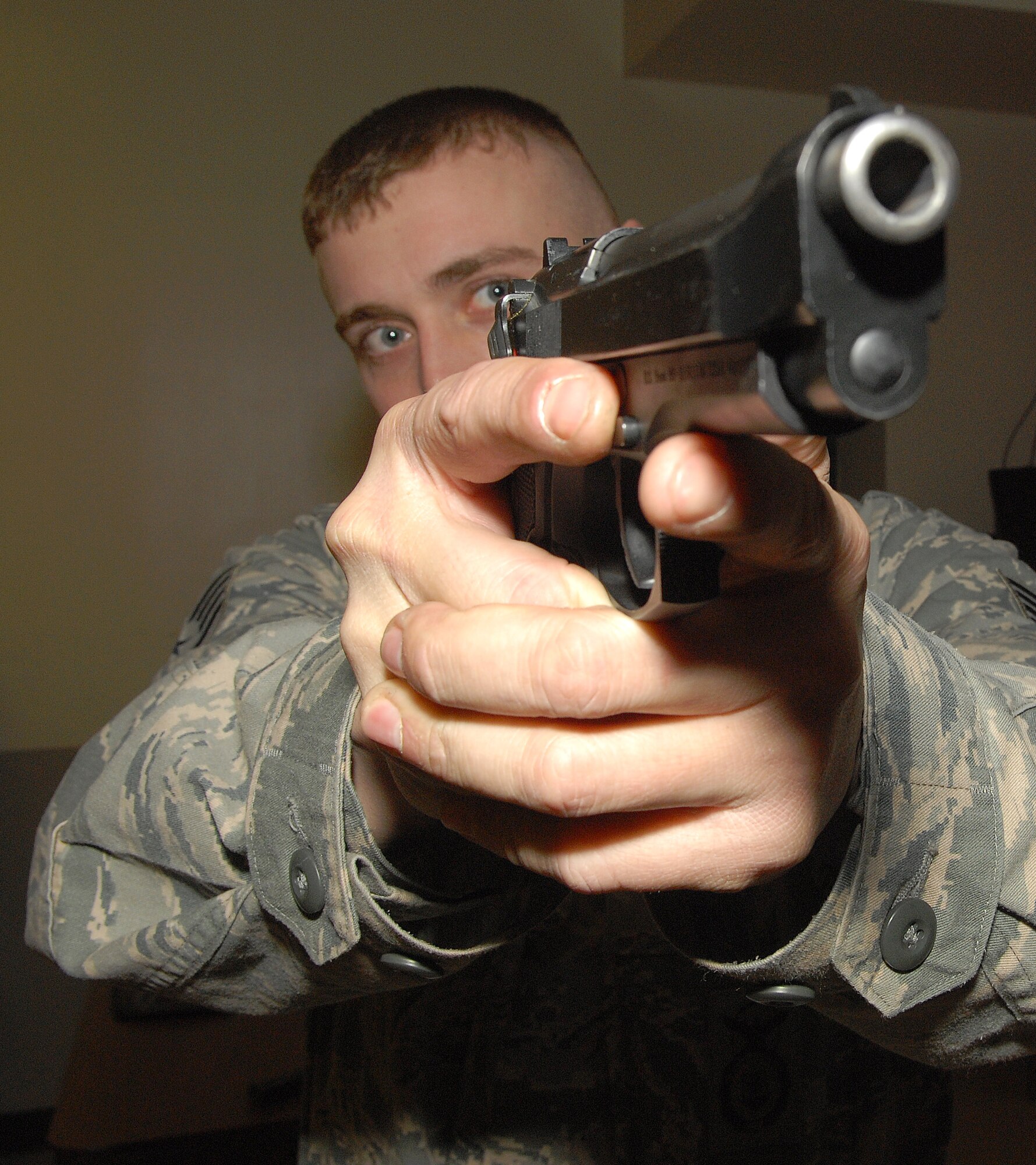 Staff Sgt. Tim Streets, 436th Security Forces Squadron combat arms instructor, demonstrates how to aim an M-9 pistol March, 4 2011, at the Combat Arms Training and Maintenance facility on Dover Air Force Base, Del. (U.S. Air Force Base photo by Airman 1st Class Samuel Taylor)