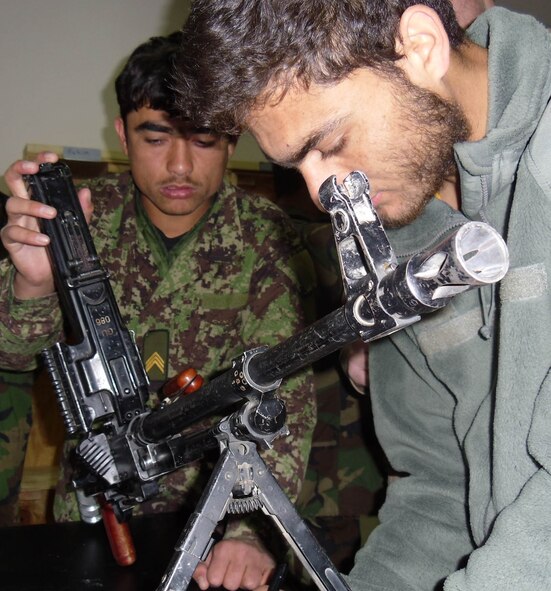 An Afghan airman (left) does professional military knowledge training on a general purpose machine gun March 8, 2011, at Shindand, Afghanistan, for part of his training to be a flying air crew chief in the Afghan air force. (U.S. Air Force photo/Staff Sgt. Justin Shults)