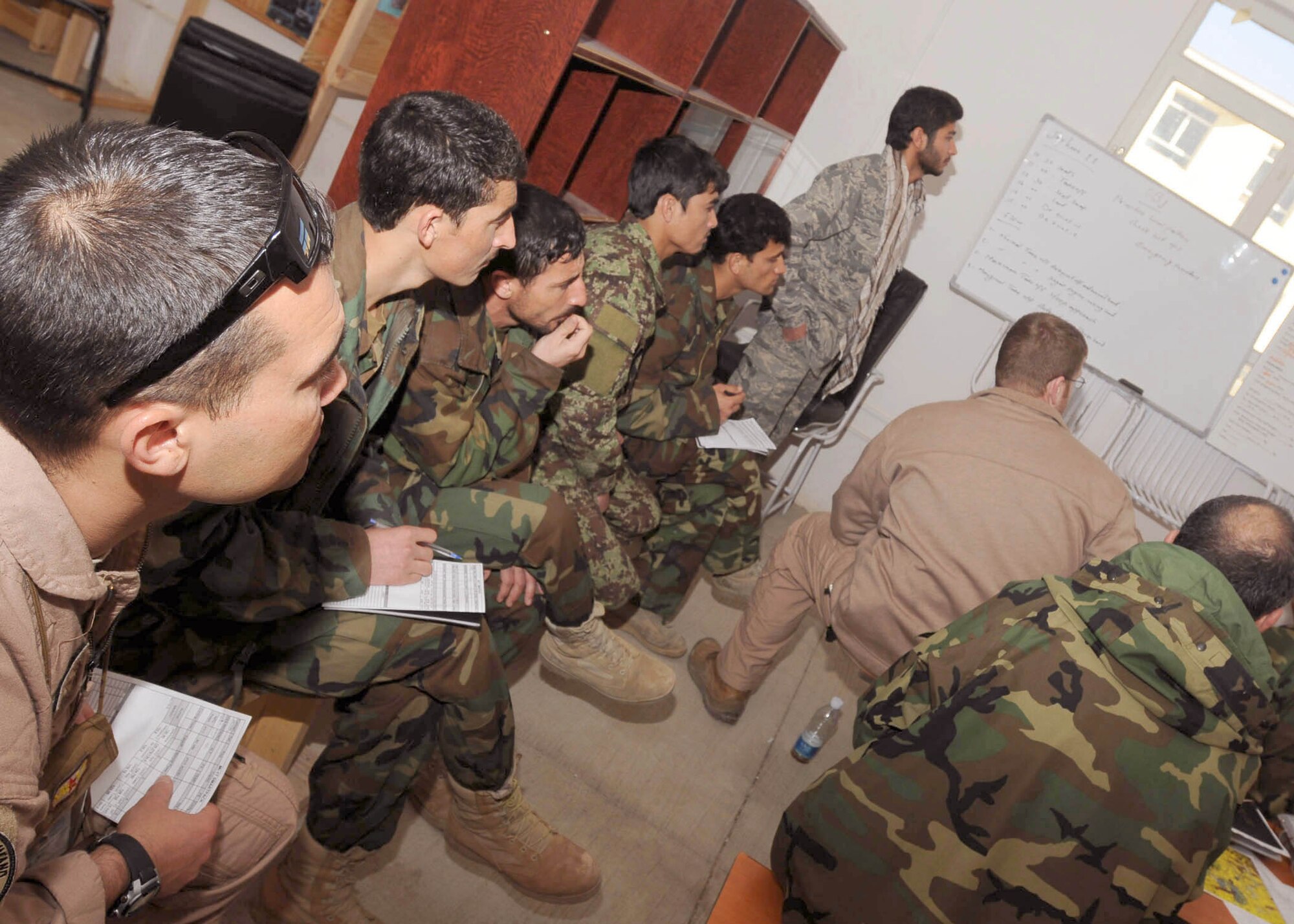 Staff Sgt. Christopher Morford sits with the four students during a mission brief March 8, 2011, at Shindand, Afghanistan. Sergeant Morford is a flying crew chief adviser with the NATO Air Training Command-Afghanistan.(U.S. Navy photo/ Petty Officer 3rd Class Jared E. Walker) 