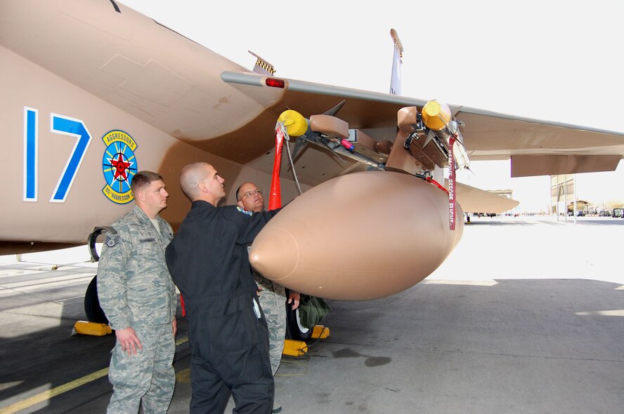 NELLIS AIR FORCE BASE, Nev. -- (Left to right) Staff Sgt. Samuel Schumach and Staff Sgt. Donnie McGurk, 926th Aircraft Maintenance Squadron, demonstrate the weapons load capability of an F-15 Eagle to Chief Master Sgt. Dwight Badgett, Air Force Reserve Command Chief, March 5. The 926th AMXS' Reserve maintainers are integrated into the Regular Air Force's 57th Maintenance Group here. (U.S. Air Force photo/Capt. Jessica Martin)