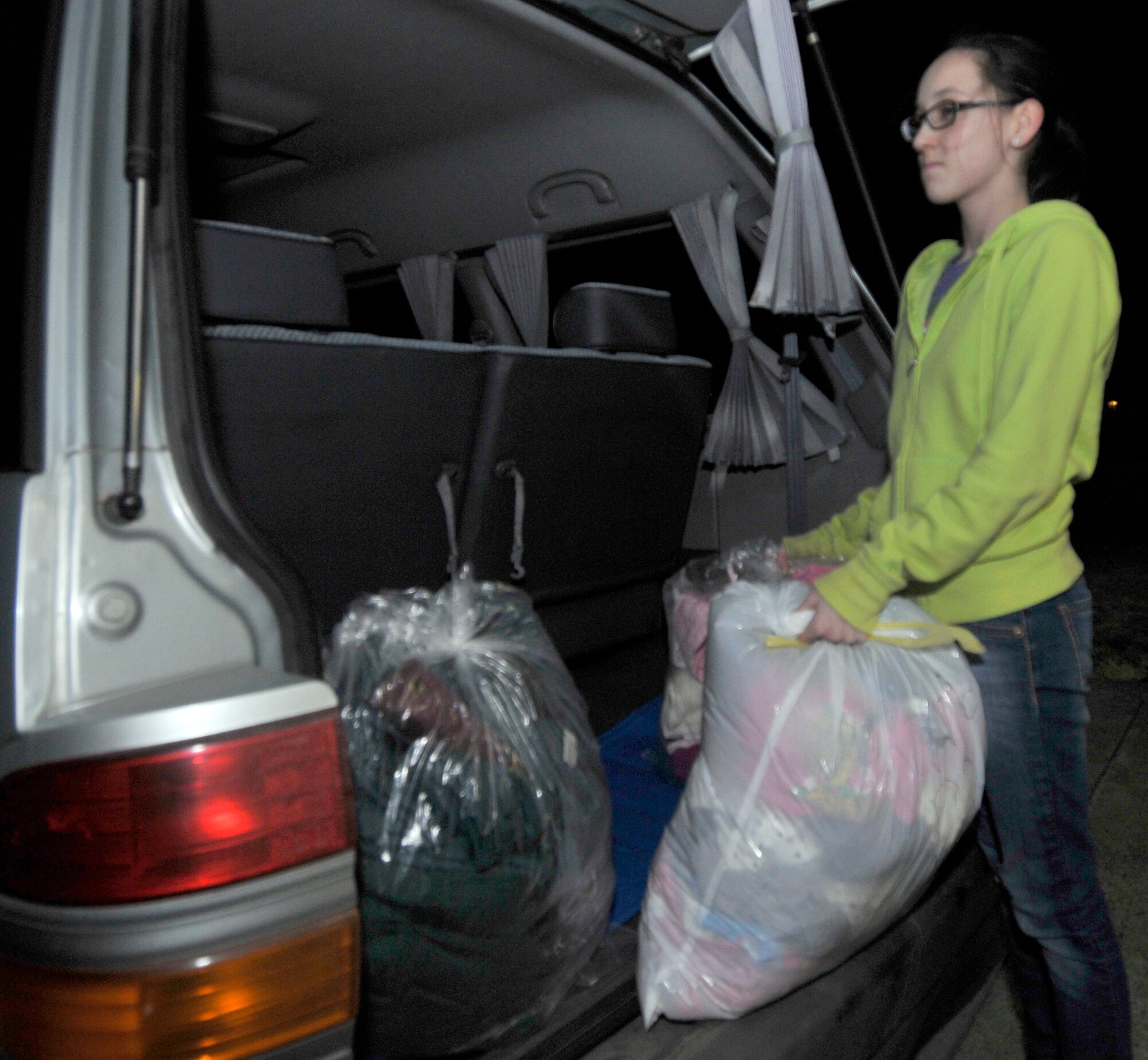 Katie O'Czopek removes bags of clothing donations from her father's van Mar. 14, 2011, at Misawa Air Base, Japan. Edgren High School officials collected donations for the Misawa City community. Ms. O'Czopek is the daughter of Mark O'Czopek, a government contractor. (U.S. Air Force photo/Tech. Sgt. Phillip Butterfield) 