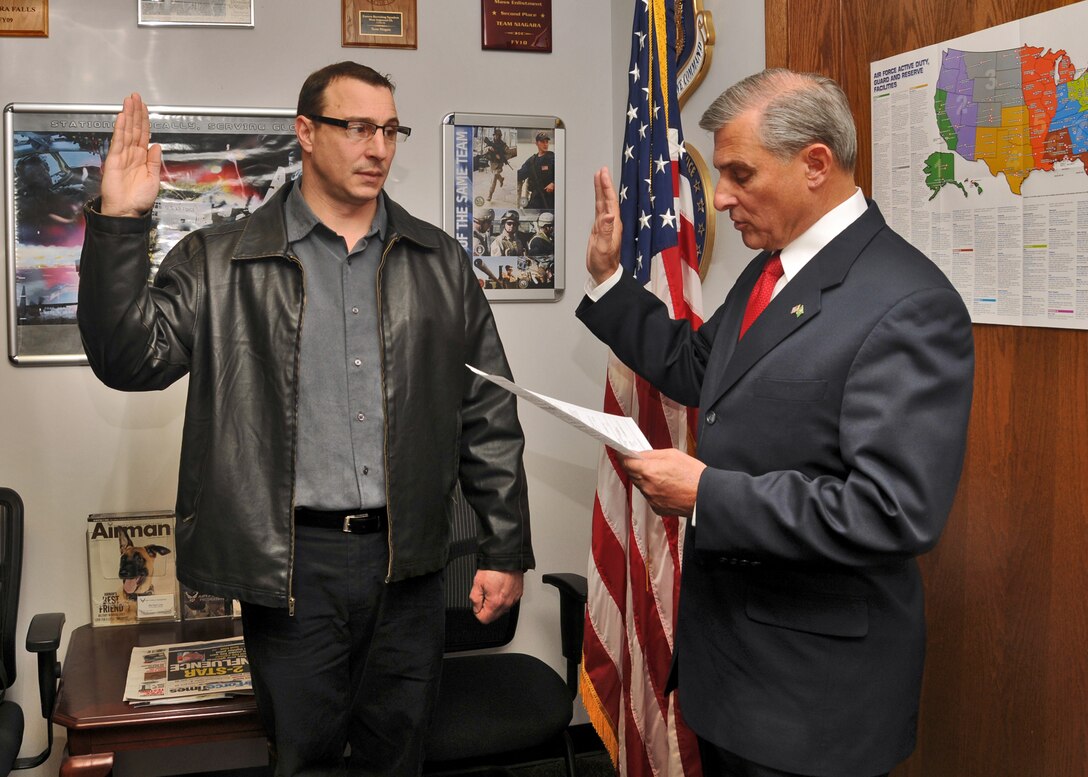 Jeffery Caruana (left) is given the oath of enlistment by his older brother, retired U.S. Army Brig. Gen. Anthony Caruana, March 14, 2011, Niagara Falls Air Reserve Station, NY. Caruana served in the U.S. Army as a drill sergeant and is now is slated to become a firefighter at the NFARS Fire Department. (U.S. Air Force photo by Staff Sgt. Joseph McKee)