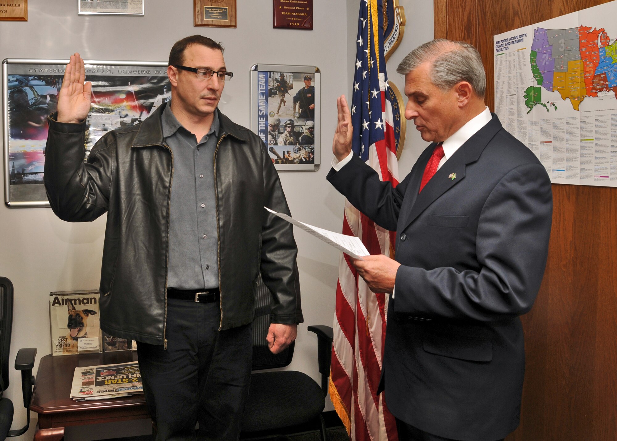 Jeffery Caruana (left) is given the oath of enlistment by his older brother, retired U.S. Army Brig. Gen. Anthony Caruana, March 14, 2011, Niagara Falls Air Reserve Station, NY. Caruana served in the U.S. Army as a drill sergeant and is now is slated to become a firefighter at the NFARS Fire Department. (U.S. Air Force photo by Staff Sgt. Joseph McKee)