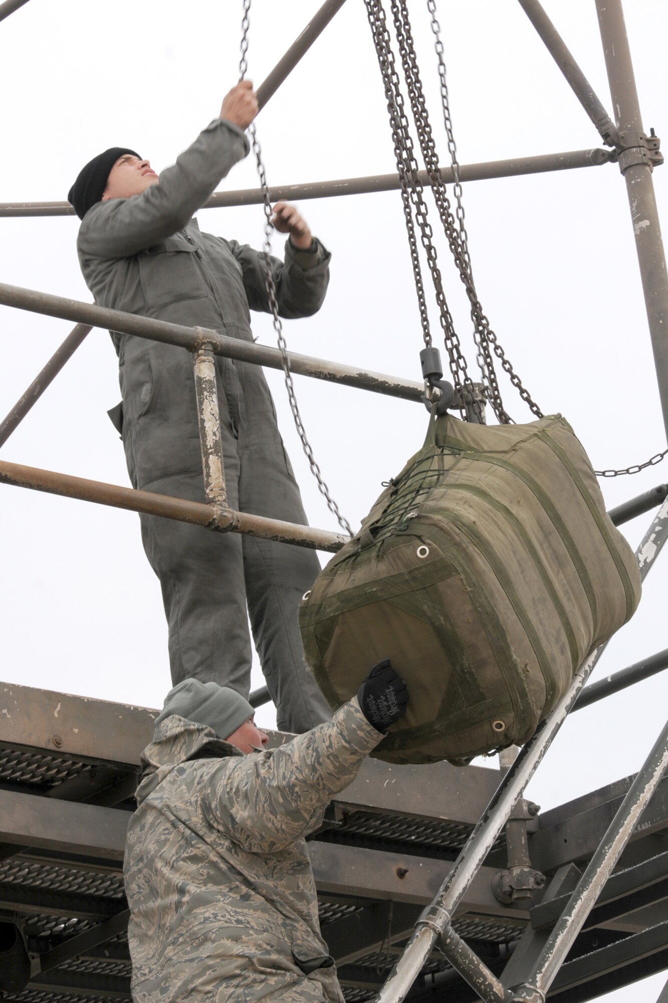 Airman 1st Class Justin Foster, 20th Aircraft Maintenance Squadron crew chief, works the chains on a B-52 Drag Chute Maintenance Stand as Tech. Sgt. Tobin Young, a 707th Maintenance Squadron crew chief, guides a drag chute up for replacement in a 2nd Bomb Wing B-52H that has just returned from a nuclear training mission at Barksdale Air Force Base, La, March 5, 2011. The 707th MXS is an Air Force Reserve classic associate unit assigned to the 2nd Maintenance Group and supports the 343rd Bomb Squadron. The launch of this crew and aircraft was significant for being the first supported by 2nd BW operations and maintenance personnel during a 307th Bomb Wing Reserve Unit Training Assembly. (U. S. Air Force Photo/Master Sgt. Greg Steele)