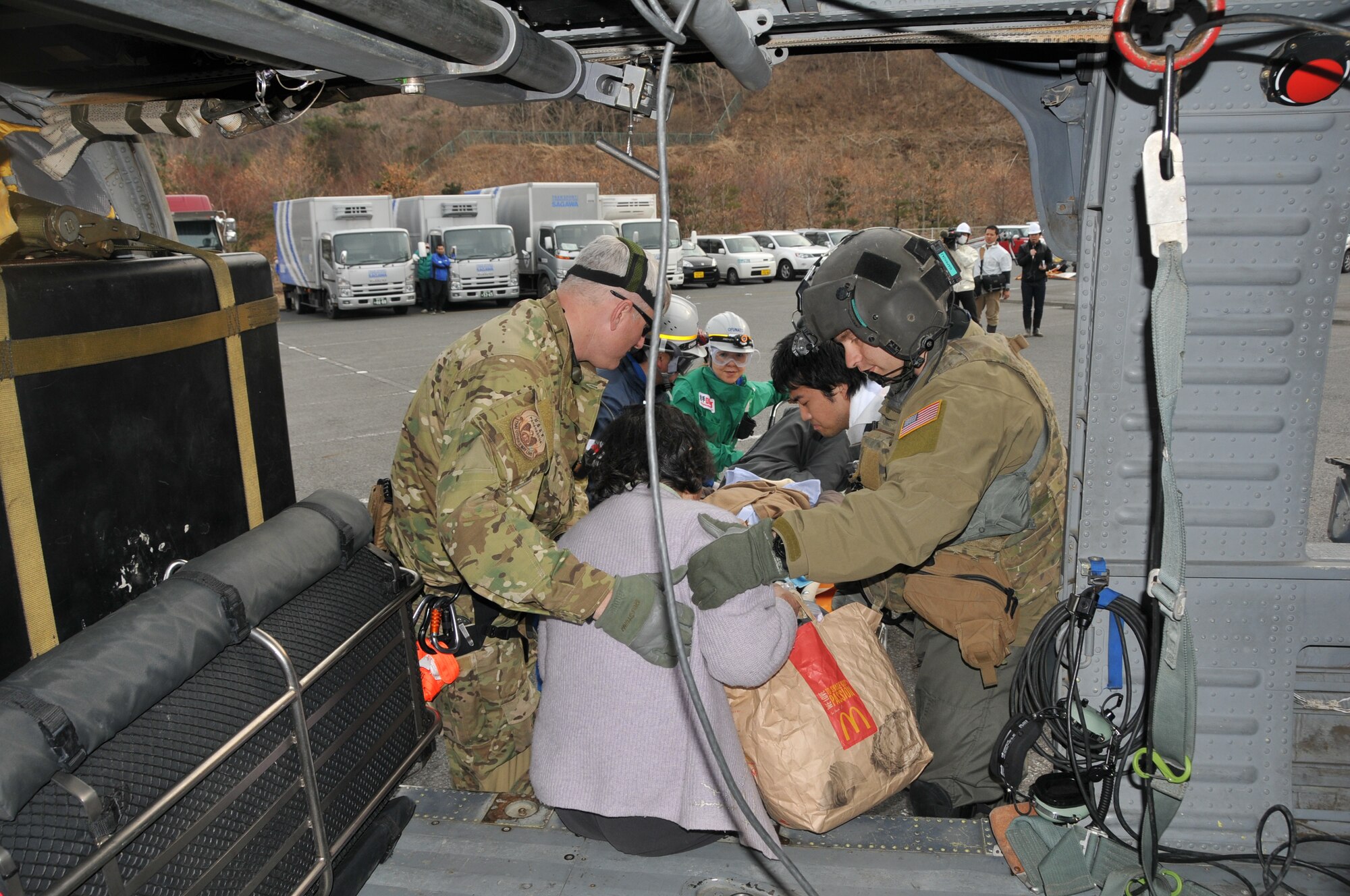SENDAI, Japan -- U.S. Air Force search and rescue personnel partner with a Japanese Disaster Medical Assistance Team to offload an earthquake victim from an HH-60G helicopter March 14. Search and rescue personnel transported the Japanese citizens from a remote island to a nearby hospital for treatment. (U.S. Air Force photo/Airman 1st Class Katrina R. Menchaca)