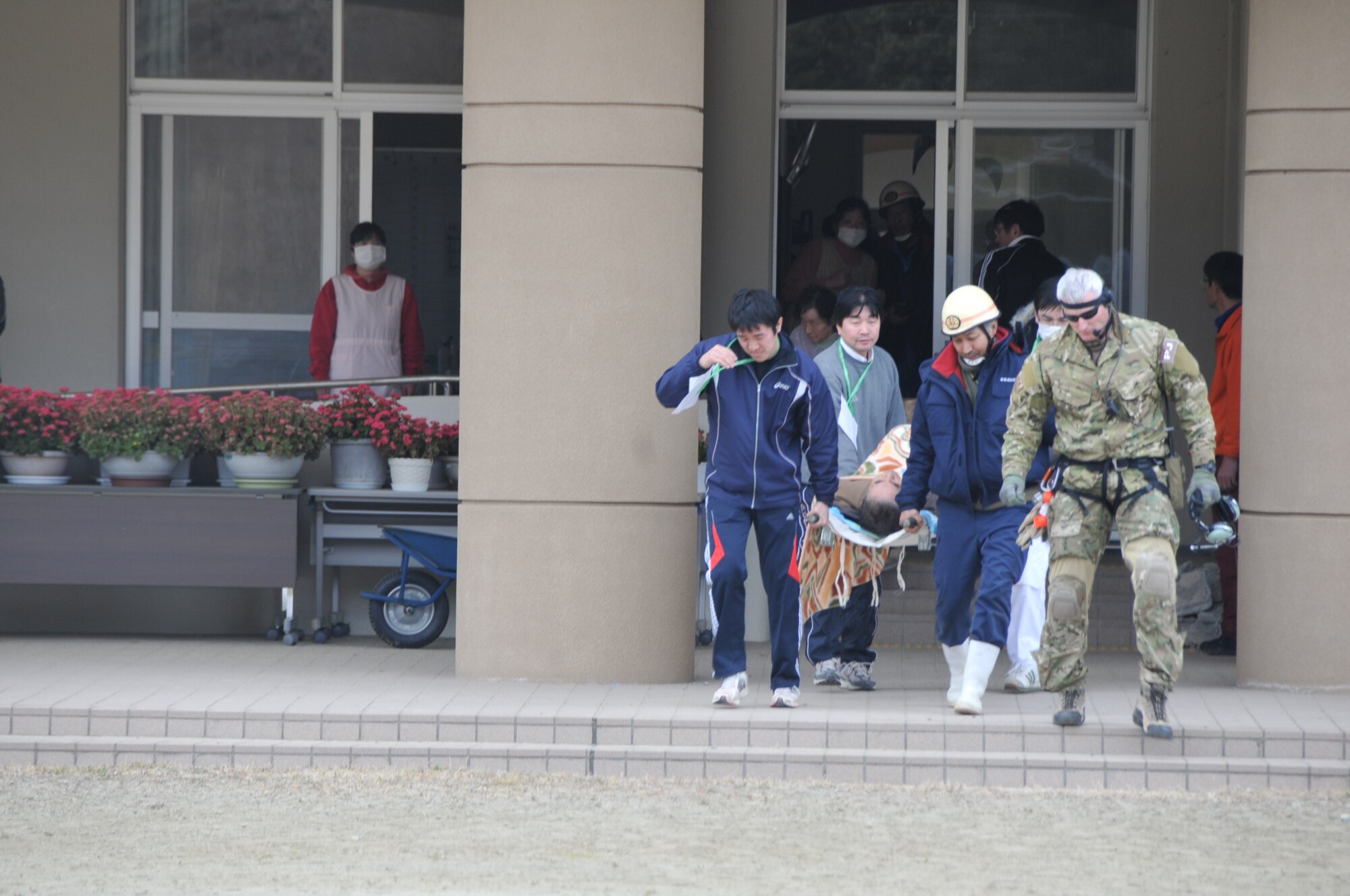 SENDAI, Japan -- A Japanese Disaster Medical Assistance Team carries an earthquake victim to an awaiting U.S.Air Force HH-60G helicopter March 14. American search and rescue personnel transported the Japanese citizen to a nearby hospital for treatment. (U.S. Air Force photo/Airman 1st Class Katrina R. Menchaca)