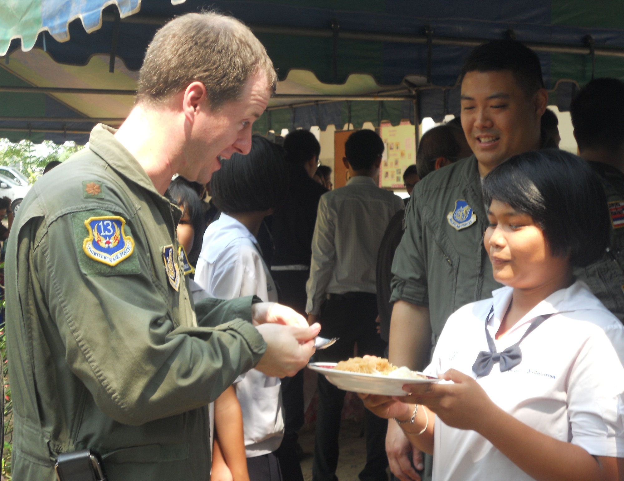 KORAT, Thailand - Maj. Greg Richert, Chief of Aerospace Medicine at 13th Air Force, Joint Base Pearl Harbor-Hickam, Hawaii, and medical lead for Exercise Cope Tiger 2011, is served noodles by a student from Ang Huay Yang School in Korat, Thailand, March 14. Airmen visited the school with members of the Royal Thai and Republic of Singapore Air Forces during Cope Tiger 2011, an annual, multilateral, joint field training exercise currently being conducted in Thailand March 14 through 25. (U.S. Air Force Photo/ Capt. Kirsten Udd)