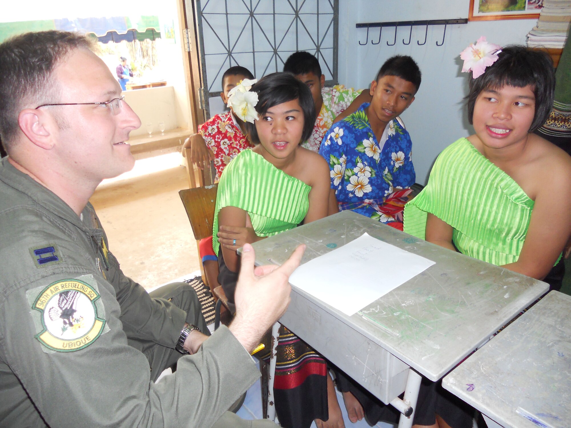 KORAT, Thailand - Capt. Jeremy Buxton, a pilot with the 96th Air Refueling Squadron from Joint Base Pearl Harbor-Hickam, Hawaii, practices his Thai with Natacha Chotsongnern and Supapon Kongpudsa from Ang Huay Yang School in Korat, Thailand, March 14. Airmen visited the school with members of the Royal Thai and Republic of Singapore Air Forces during Cope Tiger 2011, an annual, multilateral, joint field training exercise currently being conducted in Thailand March 14 through 25. (U.S. Air Force Photo/ Capt. Kirsten Udd)