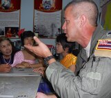 KORAT, Thailand - Lt. Col. Mike Akiowa, a pilot stationed at the 203rd Air Refueling Squadron at Joint Base Pearl Harbor-Hickam, Hawaii, explains Hawaiian history to students and teachers at the Ang Huay Yang School in Korat, Thailand March 14.  The Airmen visited the school with members of the Royal Thai and Republic of Singapore Air Forces during Cope Tiger 2011, an annual, multilateral, joint field training exercise currently being conducted in Thailand March 14 through 25. (U.S. Air Force Photo/ Capt. Kirsten Udd)
