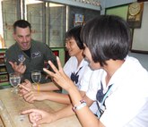 KORAT, Thailand - Capt. Tyler March, an F-15 pilot with the 44th Fighter Squadron at Kadena Air Base, Japan, learns to count in Thai with Pure Wanviag and Tup Benya, students from Ang Huay Yang School in Korat, Thailand, March 14. Airmen visited the school with members of the Royal Thai and Republic of Singapore Air Forces during Cope Tiger 2011, an annual, multilateral, joint field training exercise currently being conducted in Thailand March 14 through 25. (U.S. Air Force Photo/ Capt. Kirsten Udd)