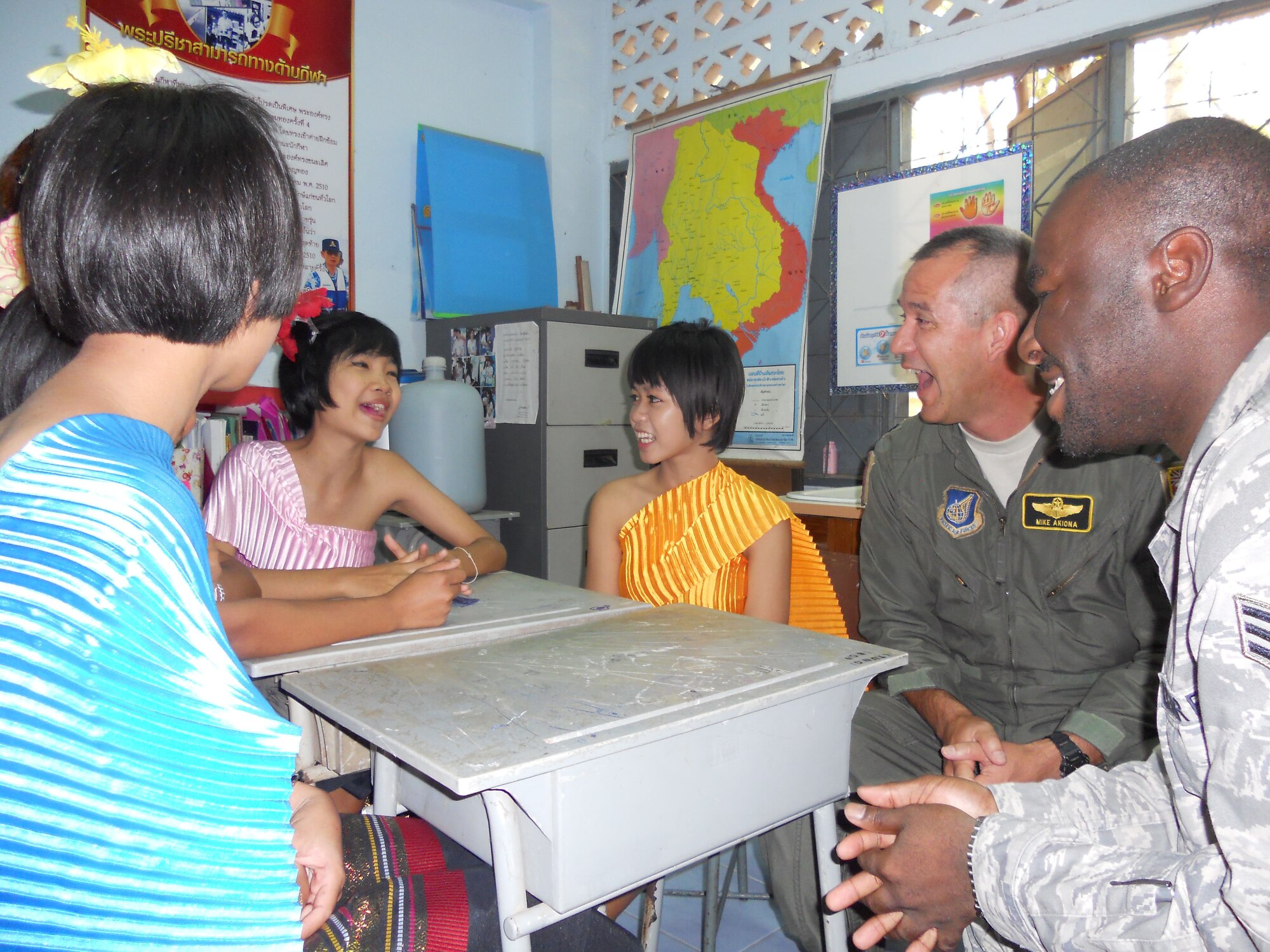 KORAT, Thailand - Lt. Col. Mike Akiowa, a pilot stationed at the 203rd Air Refueling Squadron at Joint Base Pearl Harbor-Hickam, Hawaii, and Senior Airman Antonio Savage, stationed at the 44th Fighter Squadron at Kadena Air Base, Japan, honed their Thai pronunciation skills with Panwad Aumsuan Pan and Mintra Min Bung, students from the Ang Huay Yang School in Korat, Thailand, March 14.  The Airmen visited the school with members of the Royal Thai and Republic of Singapore Air Forces during Cope Tiger 2011, an annual, multilateral, joint field training exercise currently being conducted in Thailand March 14 through 25. (U.S. Air Force Photo/ Capt. Kirsten Udd)