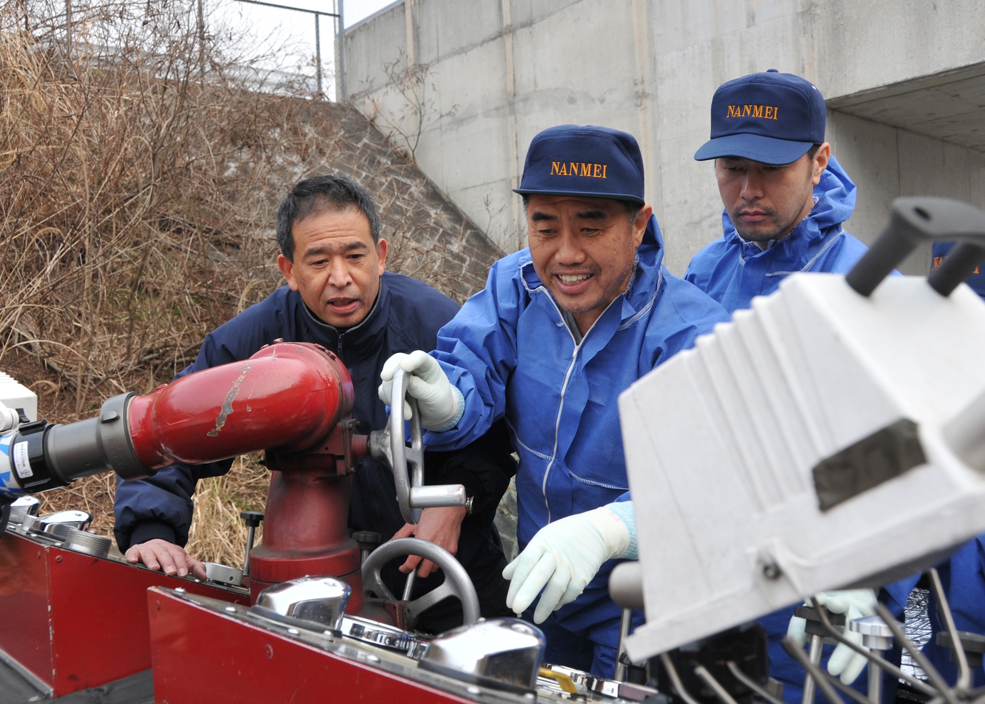 YOKOTA AIR BASE, Japan – Nobuhito Takeda, 374th Civil Engineer Squadron fire department driver operator, instructs a group of Japanese firefighters in Fukushima on how to operate a Yokota fire truck March 15. The truck will be used to assist in recovery efforts in response to the earthquake and tsunami March 11. (U.S. Air Force photo/Airman 1st Class Andrea Salazar)