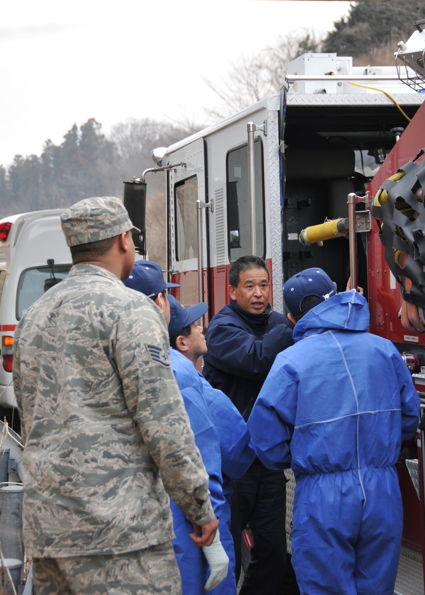 YOKOTA AIR BASE, Japan – Staff Sgt. Larry Gee, 374th Civil Engineer Squadron firefighter, looks on as Nobuhito Takeda, 374th CES fire department driver operator, instructs a group of Japanese firefighters from Fukushima on how to operate a Yokota fire truck March 15. The truck will be used to assist in recovery efforts in response to the earthquake and tsunami March 11. (U.S. Air Force photo/Airman 1st Class Andrea Salazar)