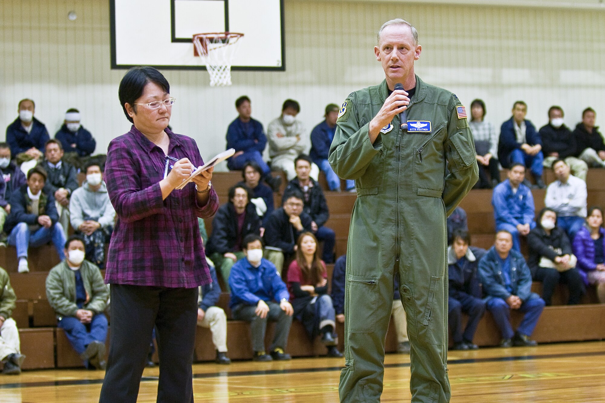 YOKOTA AIR BASE, Japan -- Col. Otto Feather, 374th Airlift Wing commander, hosts a town hall meeting for Japanese national employees, while Mitsuru Takahashi, 374th AW chief of community relations, translates the commander's information to read back to audience members here March 15. Colonel Feather focused on addressing concerns related to base information following the earthquake and tsunami in Japan March 11. (U.S. Air Force photo/Staff Sgt. Robin Stanchak)
