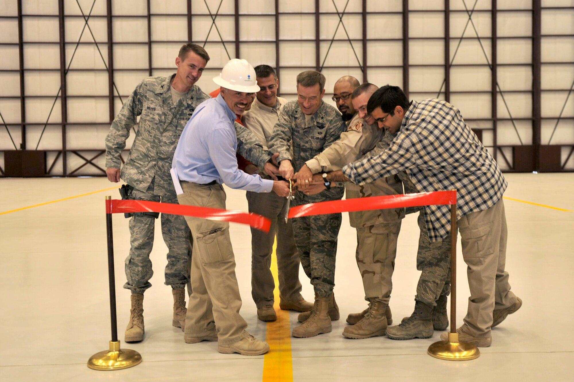 Brig. Gen. Jack Briggs, 455th Air Expeditionary Wing commander, helps cut the ribbon to the new C-130 hangar, Bagram Airfield, Afghanistan, March 14, 2011. The new C-130 hangar will be the 455th Expeditionary Aircraft Mainenance Squadron's new home. (U.S. Air Force photo by Senior Airman Sheila deVera) 