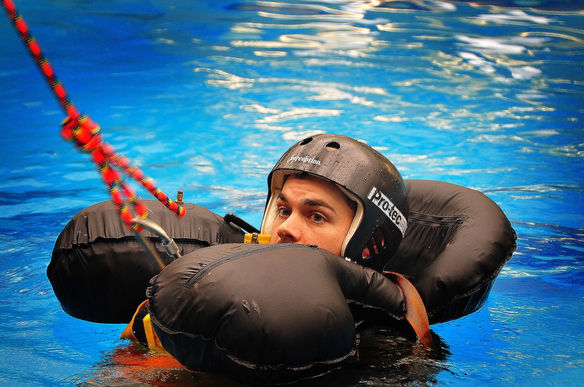 During operational readiness exercise Beverly Midnight 11-02,  Capt. Kyle Crosby, 36th Squadron pilot, completed his water survival training evaluation, Osan Air Base, Republic of Korea, March 14.  The evaluation consisted of one-on-one scenarios requiring a member to lift oneself into a one-person raft,  identify three points of air entry to inflate the sides of the raft, demonstrate a canap? disentanglement technique by following a parachute line under water that lead the pilot to a clear area, simulating the experience of being caught under a parachute while in the water, and the final task, being dragged by a pulley through the water mimicking the feeling of wind catching the canopy of the parachute and dragging the pilot through water.  (U.S. Air Force Photo By Staff Sgt. Daylena Gonzalez)