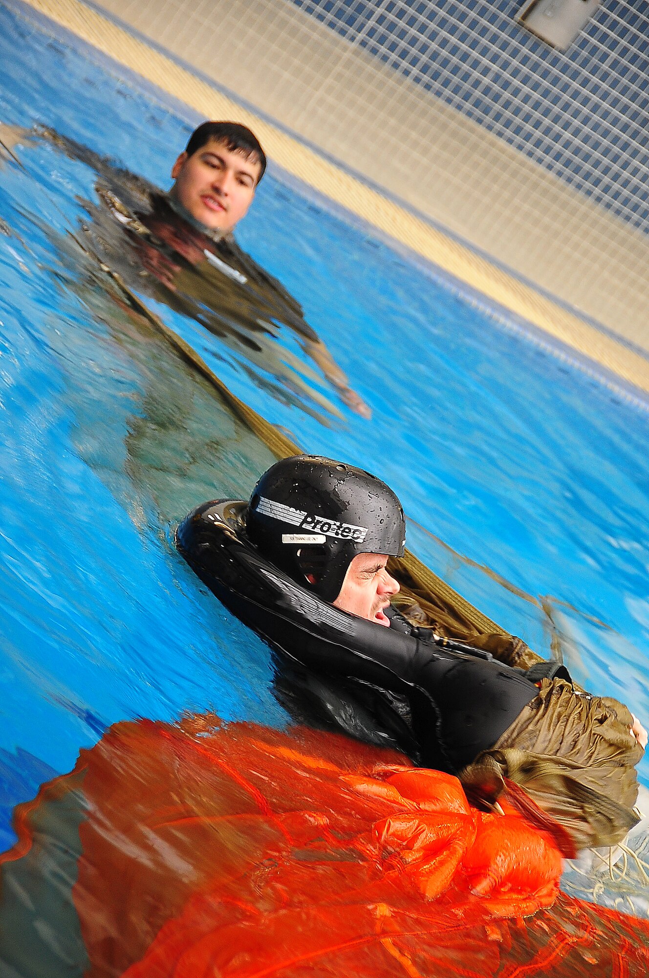 During operational readiness exercise Beverly Midnight 11-02,  Capt. Kyle Crosby, 36th Squadron pilot, completed his water survival training evaluation, Osan Air Base, Republic of Korea, March 14.  The evaluation consisted of one-on-one scenarios requiring a member to lift oneself into a one-person raft,  identify three points of air entry to inflate the sides of the raft, demonstrate a canap? disentanglement technique by following a parachute line under water that lead the pilot to a clear area, simulating the experience of being caught under a parachute while in the water, and the final task, being dragged by a pulley through the water mimicking the feeling of wind catching the canopy of the parachute and dragging the pilot through water.  (U.S. Air Force Photo By Staff Sgt. Daylena Gonzalez)