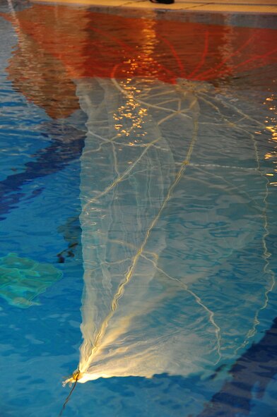 During operational readiness exercise Beverly Midnight 11-02,  Capt. Kyle Crosby, 36th Squadron pilot, completed his water survival training evaluation, Osan Air Base, Republic of Korea, March 14.  The evaluation consisted of one-on-one scenarios requiring a member to lift oneself into a one-person raft,  identify three points of air entry to inflate the sides of the raft, demonstrate a canap? disentanglement technique by following a parachute line under water that lead the pilot to a clear area, simulating the experience of being caught under a parachute while in the water, and the final task, being dragged by a pulley through the water mimicking the feeling of wind catching the canopy of the parachute and dragging the pilot through water.  (U.S. Air Force Photo By Staff Sgt. Daylena Gonzalez)